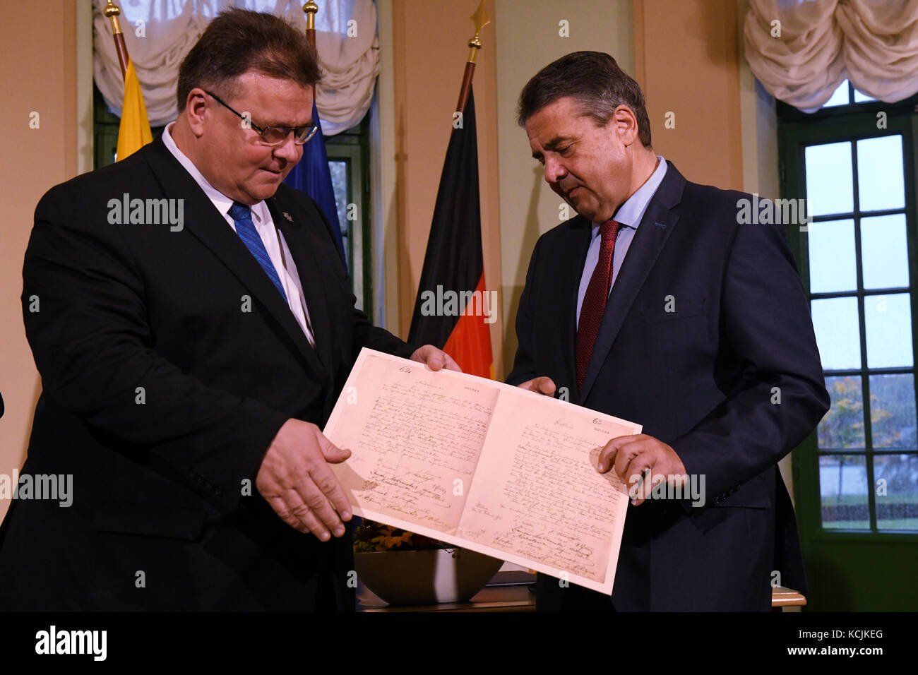 Berlin, Deutschland. Oktober 2017. Der deutsche Außenminister Sigmar Gabriel (SPD, r) und sein litauischer Amtskollege Linas Linkevicius halten am 5. Oktober 2017 in Berlin ein Dokument über die Unabhängigkeit Litauens vor. Kredit: Maurizio Gambarini/dpa/Alamy Live News Stockfoto