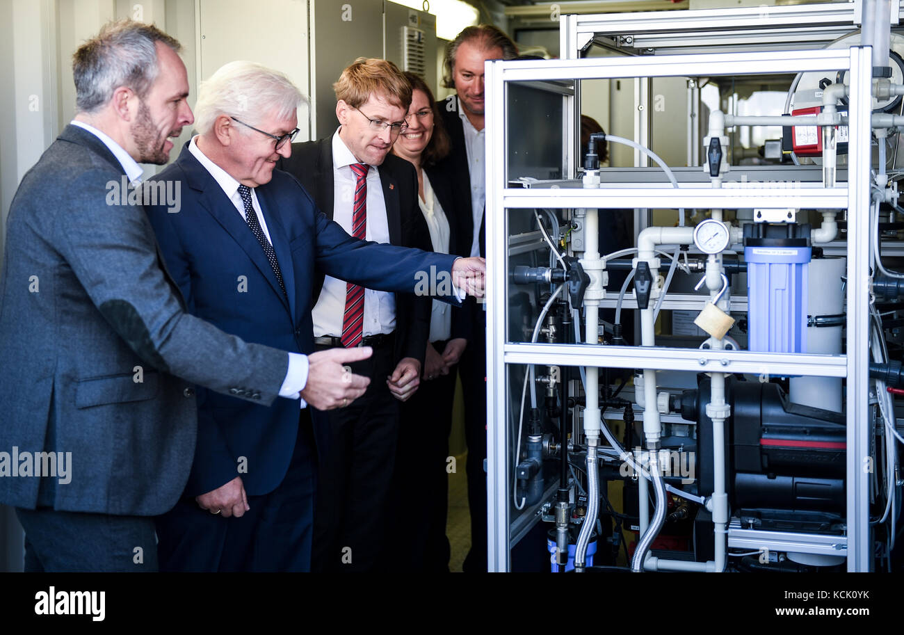 Der Vorsitzende der Firma 'GP Joule', Ove Petersen (L) und Heinrich Gaertner (R) zeigen Bundespräsident Frank-Walter Steinmeier (2-L), Premierminister Daniel Guenther und seine Frau Anke Maschinen, die bei der Firma 'GP Joule' in Reußenkoege, Deutschland, am 6. Oktober 2017 zurückbleibende Windenergie in Wasserstoff verwandeln können. Steinmeier besucht derzeit Schleswig-Holstein. Foto: Axel Heimken/dpa Stockfoto