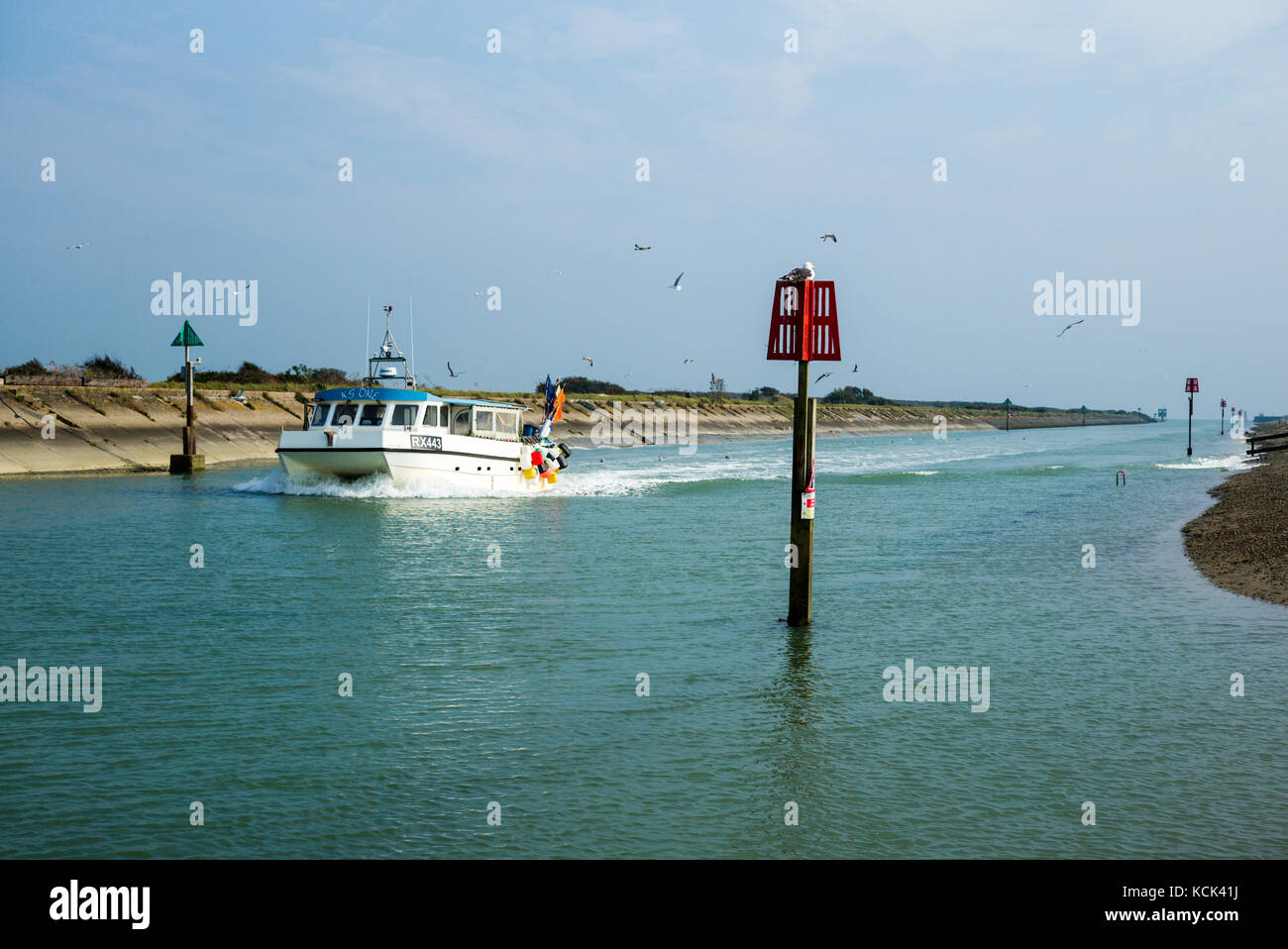 Ein Fischerboot kehrt in Roggen Hafen in East Sussex Stockfoto