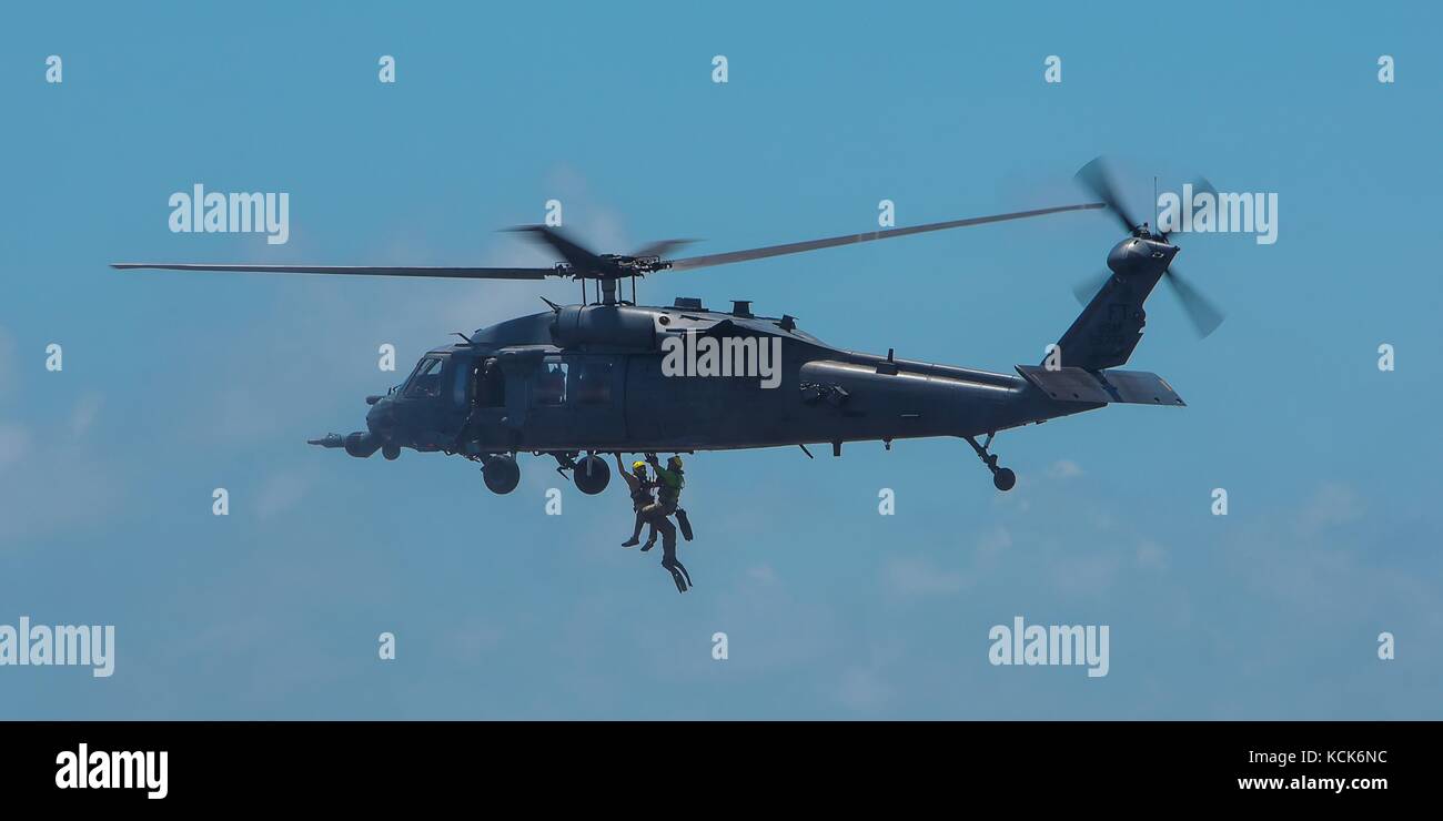 Ein HH-60 Pave Hawk Helikopter der US Air Force hebt zwei US-Soldaten während eines Wasserrettungsszenarios während der Übung Stealth Guardian am 7. August 2017 in Carrabelle, Florida. (Foto: Tybee Hurst via Planetpix) Stockfoto