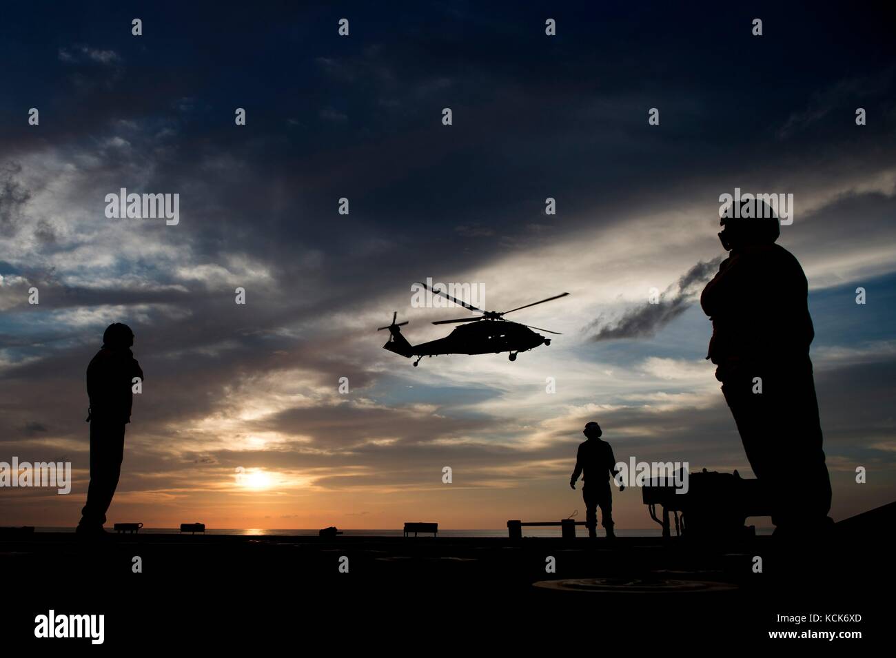 Ein Hubschrauber der US Navy MH-60S Seahawk landet am 5. August 2017 im Südchinesischen Meer bei Sonnenuntergang auf dem Flugdeck an Bord des US Navy Independence-Kampfschiffs USS Coronado. (Foto: MCS3 Deven Leigh Ellis via Planetpix) Stockfoto