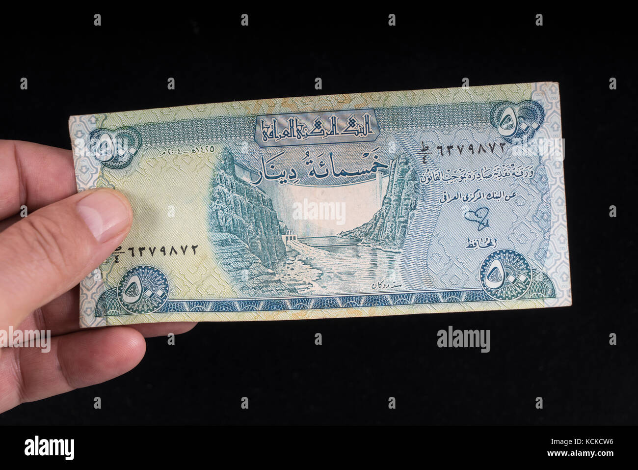 Eine alte irakische Banknote auf der Hand Stockfoto