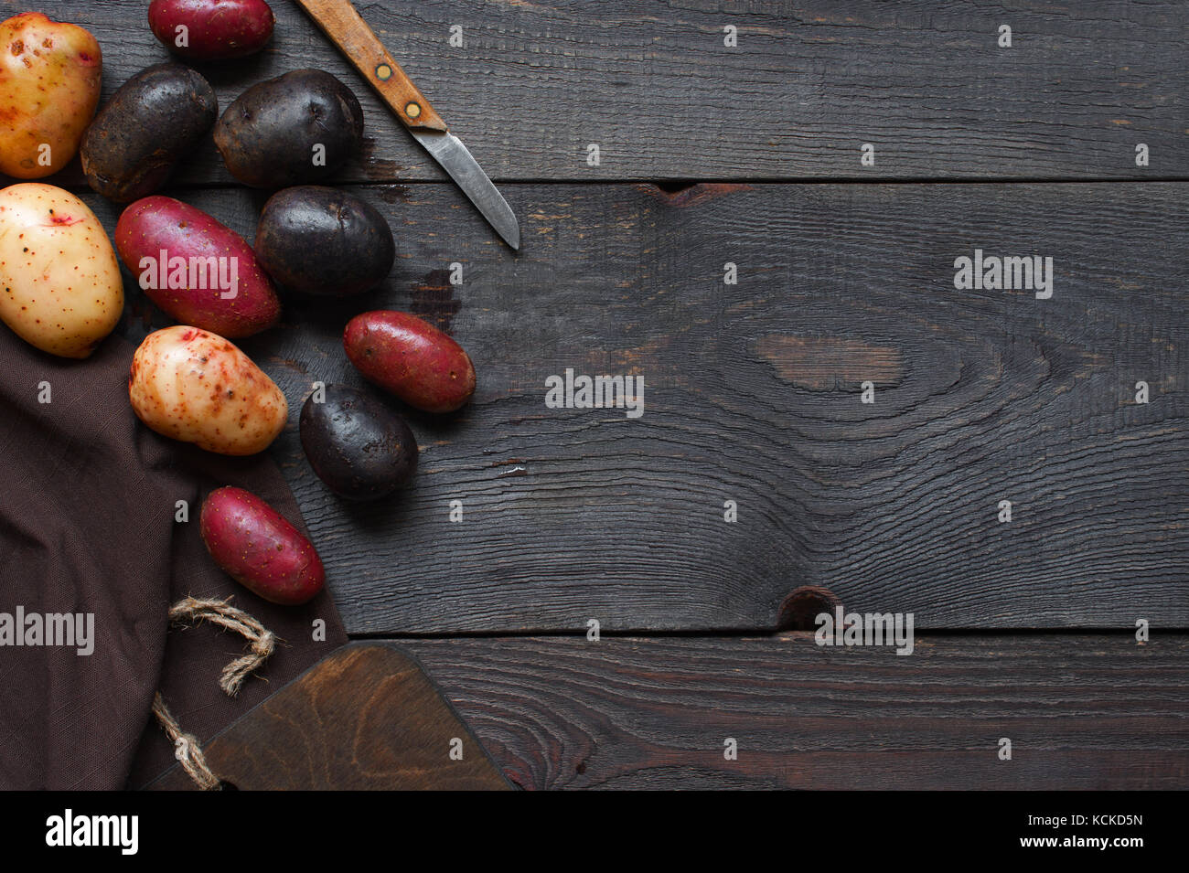 Küche aus Holz Hintergrund mit bunten Kartoffeln Stockfoto