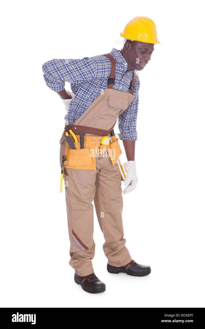 Junge Handwerker mit Rückenschmerzen Over White Background Stockfoto