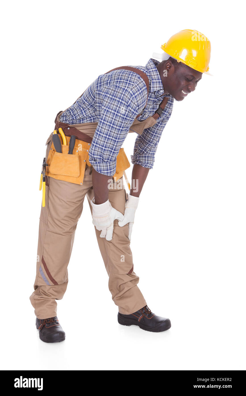 Junge männliche Handwerker leiden unter Schmerzen im Knie Over White Background Stockfoto
