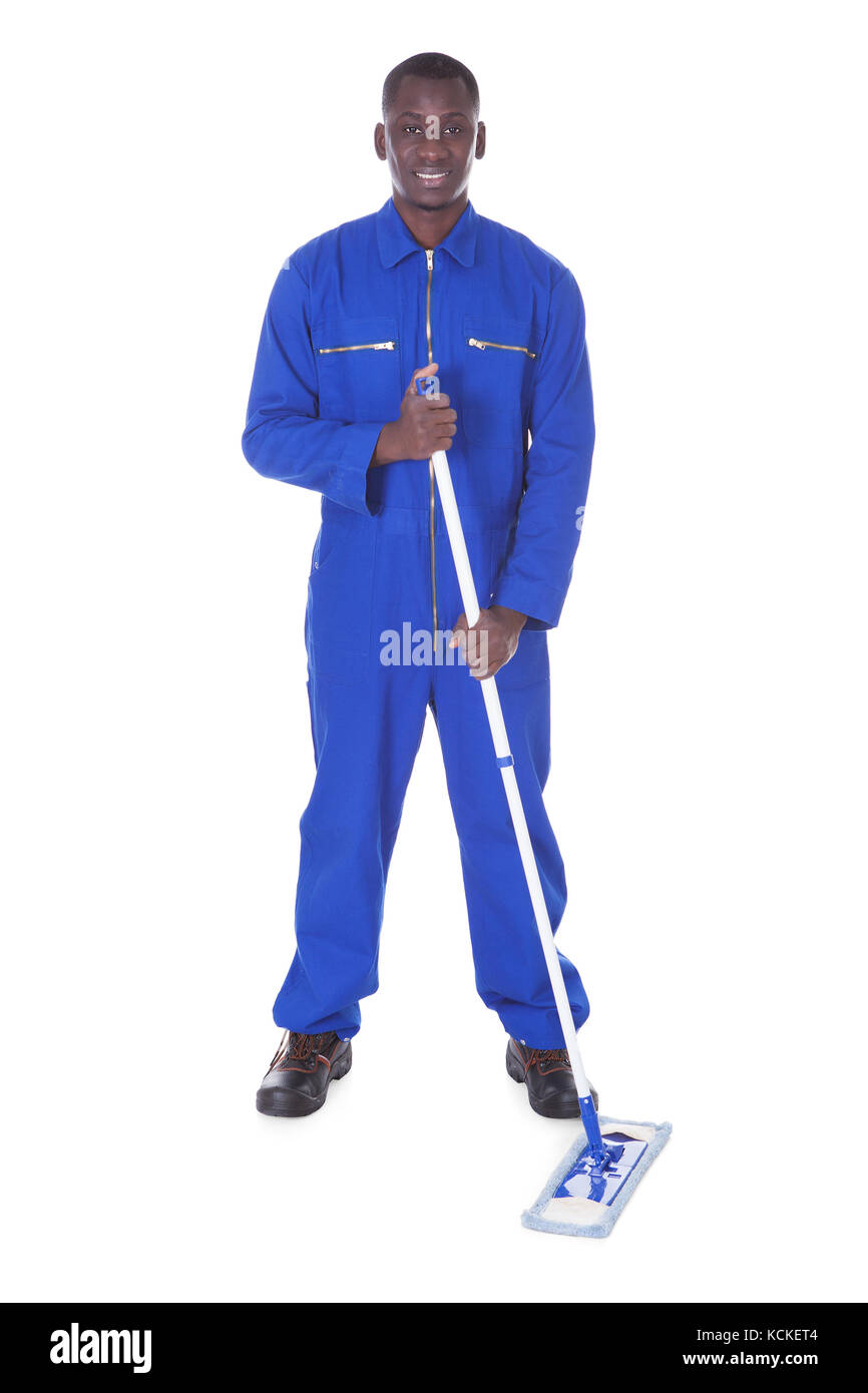 Junger Mann im blauen Blaumann Holding Mop Over White Background Stockfoto