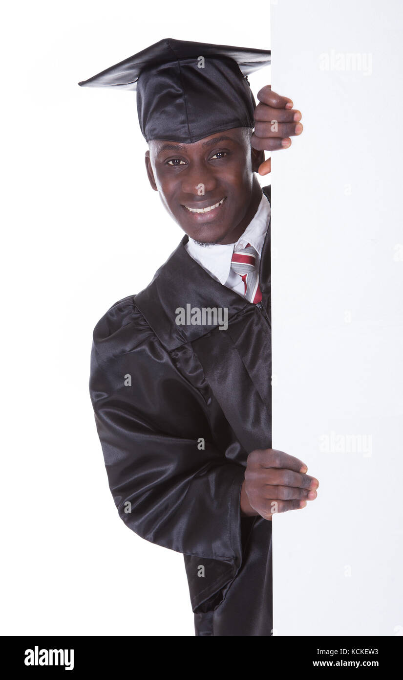 Junge Graduierung Mann mit leeren Plakatwand Over White Background Stockfoto