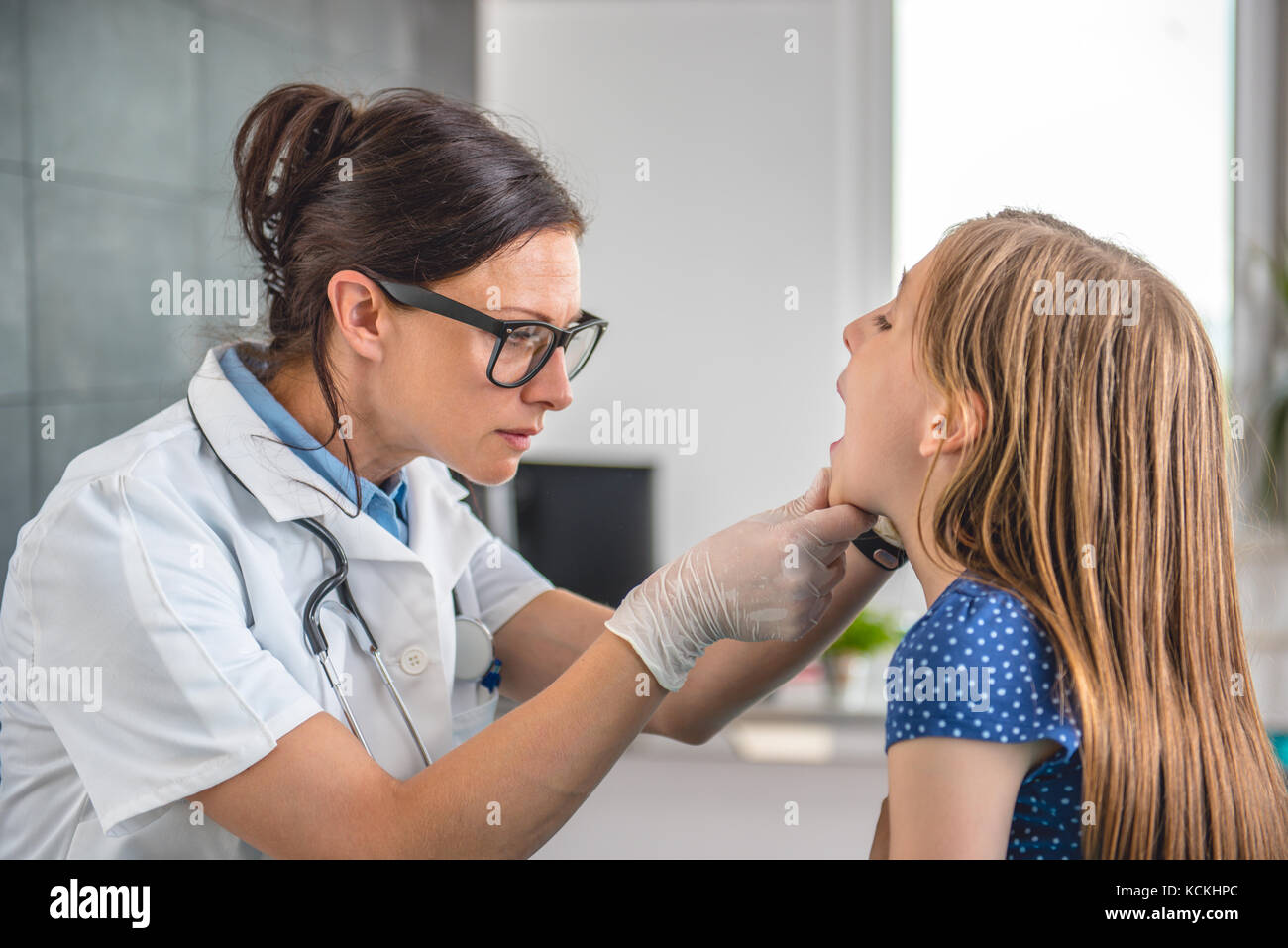 Ärztin überprüfen die Kehle kleines Mädchen an medizinischen Büro Stockfoto