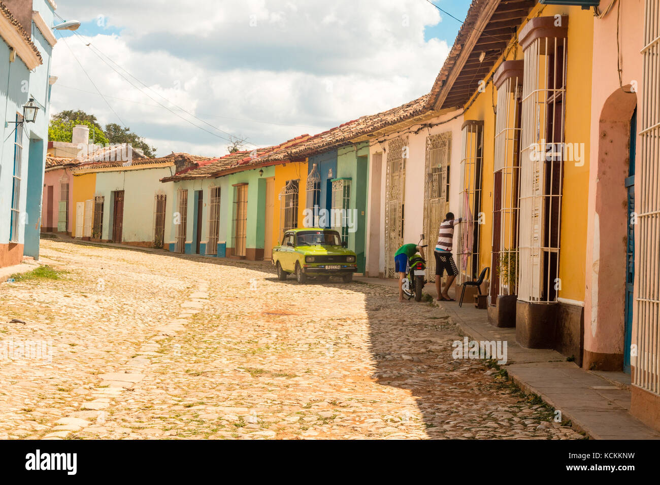 Street Scene alter amerikanischer Wagen geparkt Berufskranheiten bunte Häuser im Kolonialstil auf der Straße mit Kopfsteinpflaster, Trinidad, Kuba, Karibik, Stockfoto