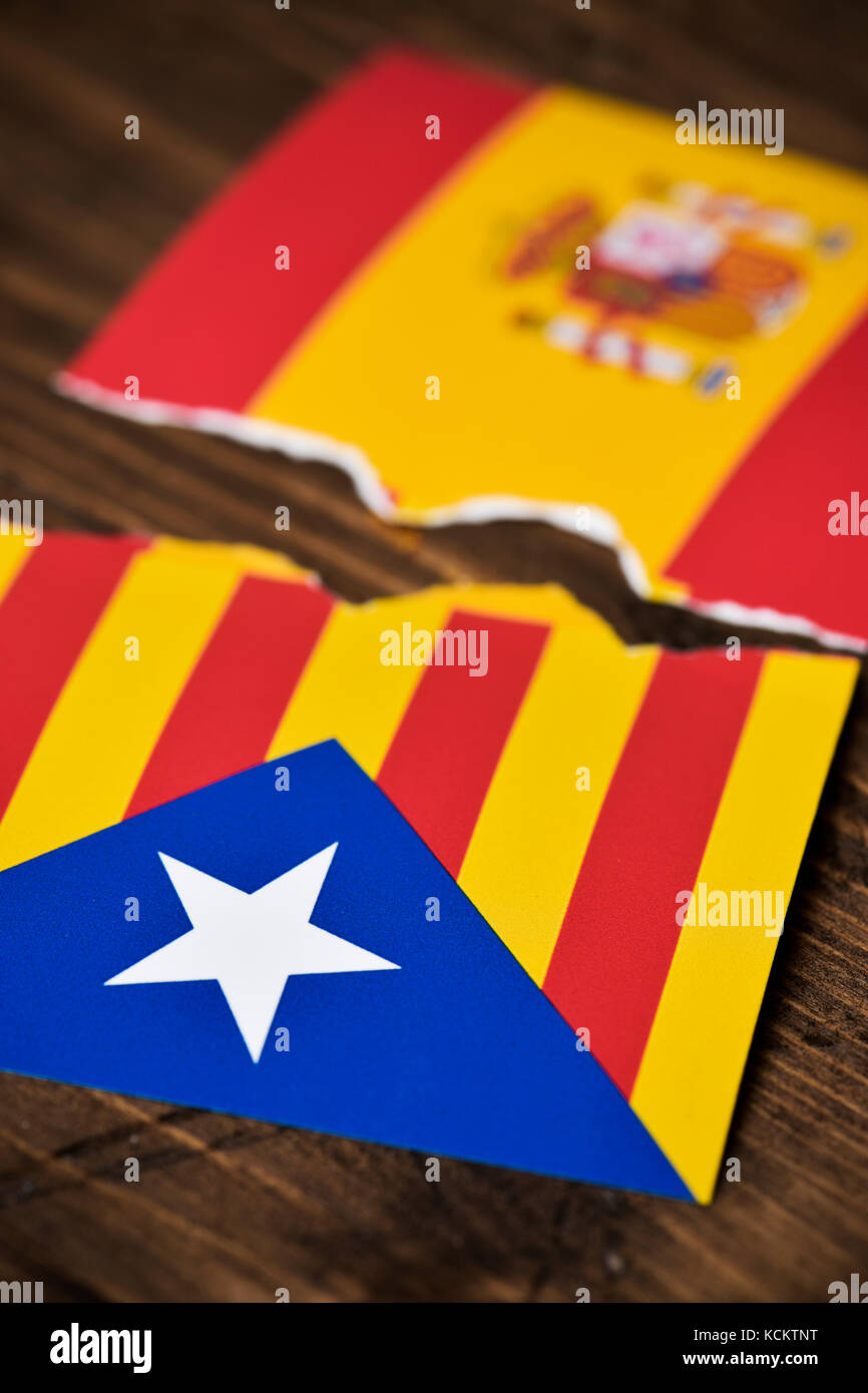 Die Estelada, die katalanische Pro-Unabhängigkeit-Flagge und die Flagge Spaniens, gebrochen auf einer rustikalen Holzfläche Stockfoto