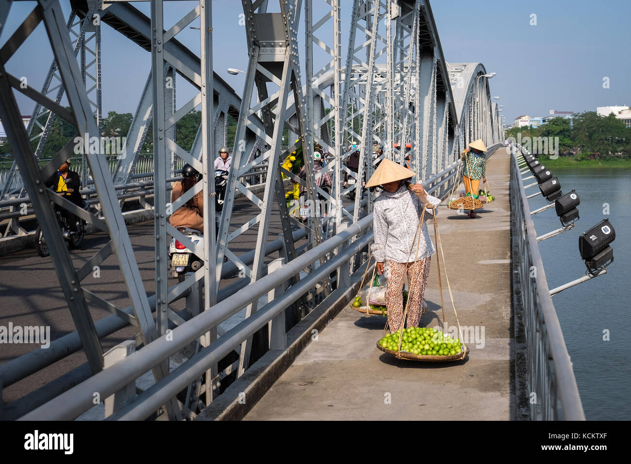 Straßenhändler zu Fuß mit ihren frischen Produkten von Dong Ba Markt über Truong Tien Brücke (Cầu Trường Tiền) Stockfoto