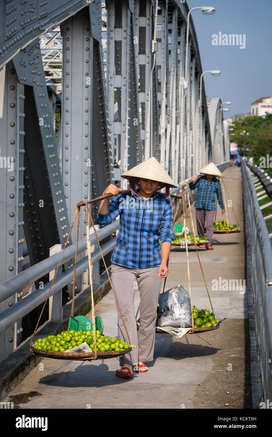 Straßenhändler zu Fuß mit ihren frischen Produkten von Dong Ba Markt über Truong Tien Brücke (Cầu Trường Tiền) Stockfoto