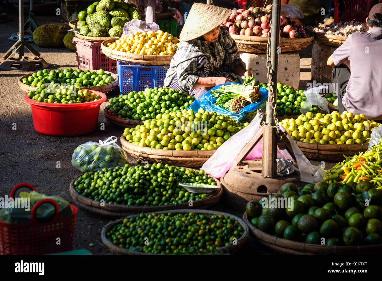Eine weibliche Markt Anbieter in einer konischen hat den Verkauf von Limes in Dong Ba Markt, Hue Abschaltdruck Stockfoto