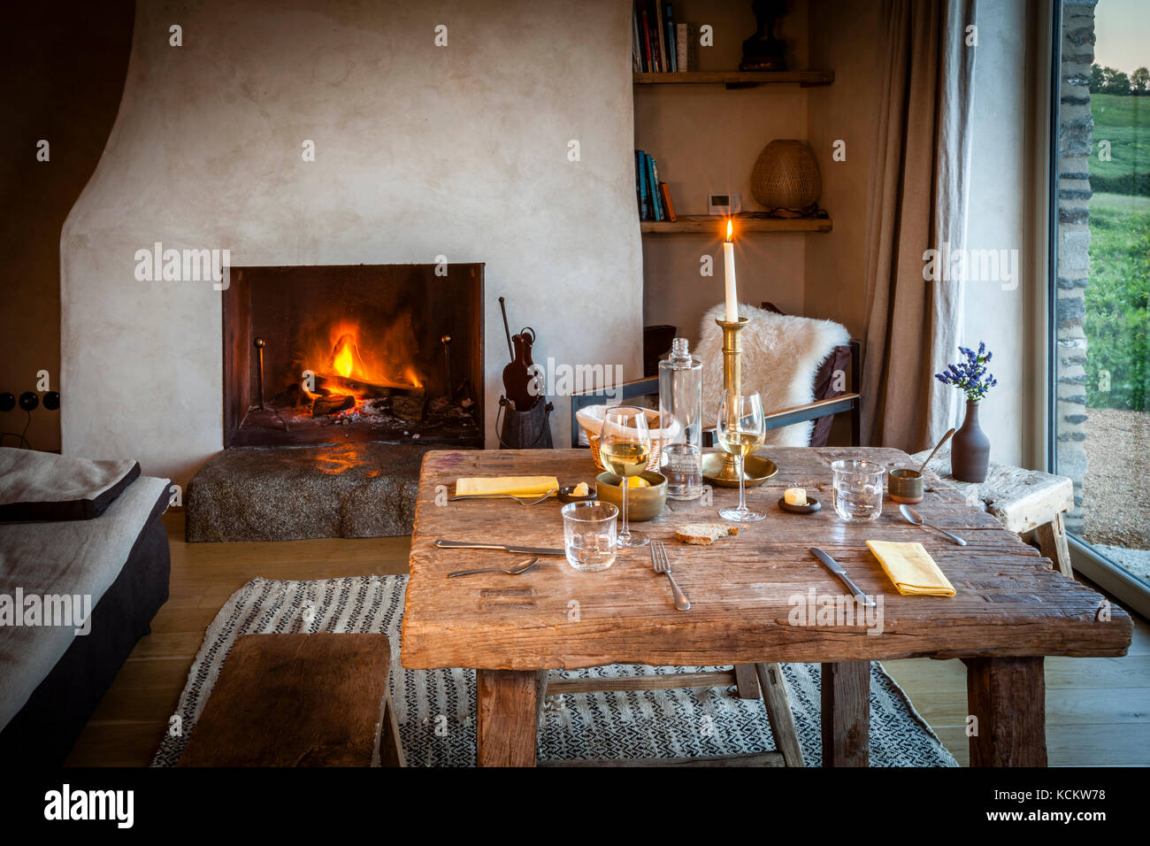 Abendessen an den eigenen vier Wänden. Der Kamin brennt und das Hauptgericht kann im Ausland in den Ofen gestellt werden. Ferme du Vent in der Nähe von Château Richeux, Saint-Malo, Frankreich Stockfoto