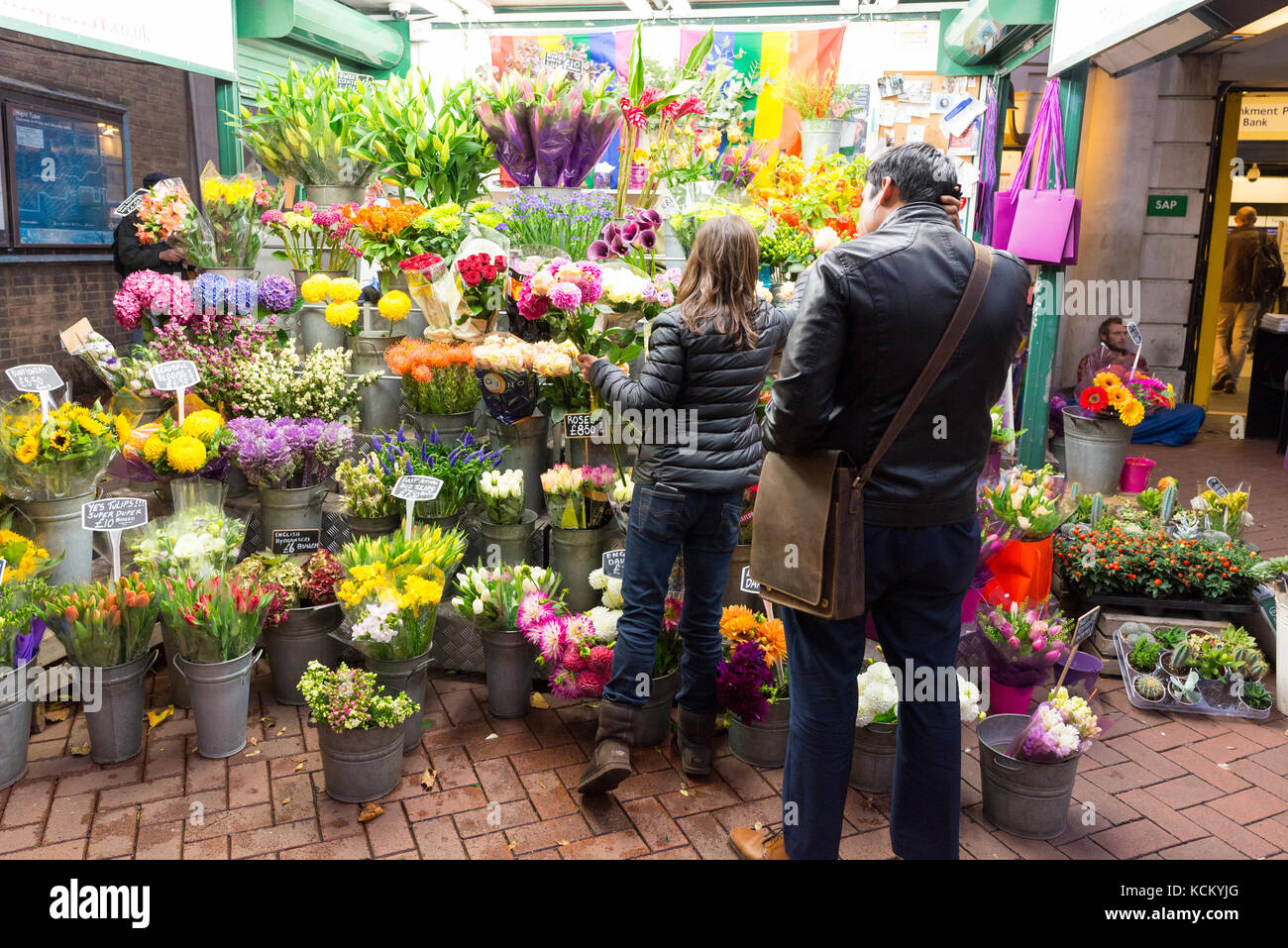 Mann kaufen Blumen vom Floristen außerhalb der U-Bahnstation Embankment, London, England, Großbritannien Stockfoto