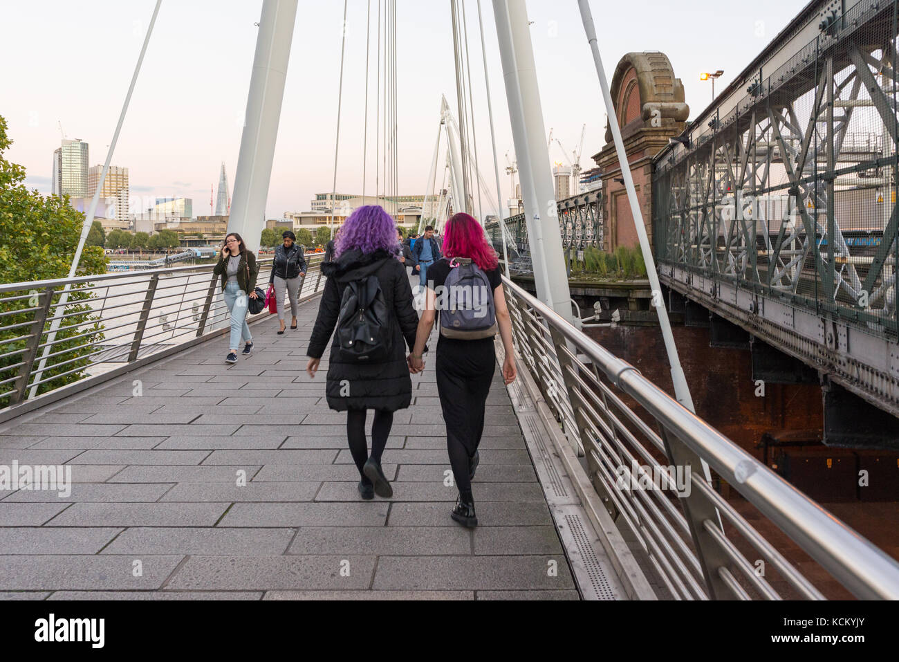 Zwei Mädchen mit roten und violetten Haare, Hände halten, London, England, Großbritannien Stockfoto