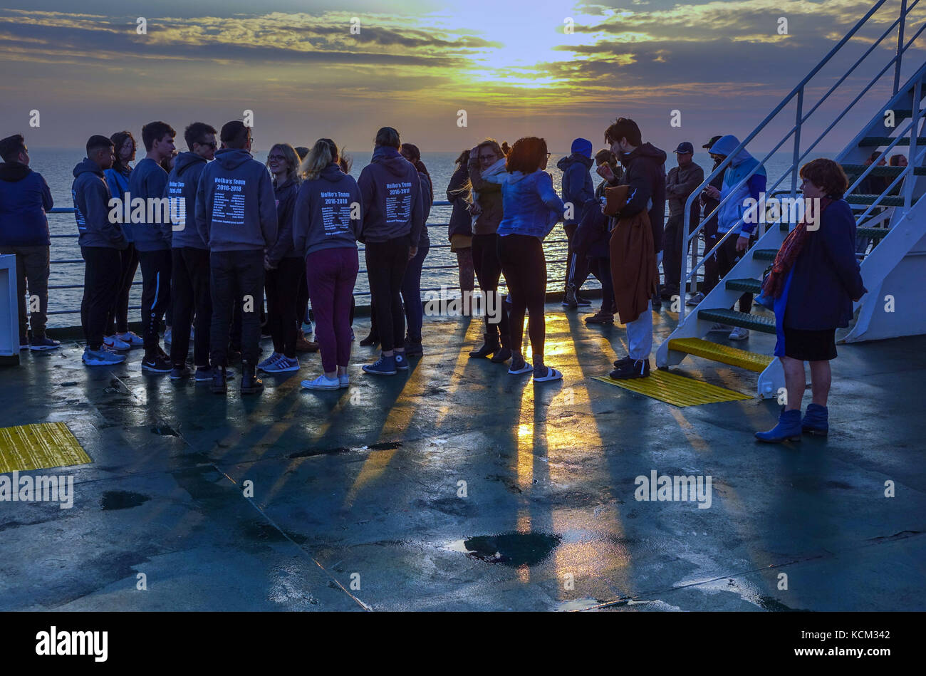 Menge von Studierenden bei Sonnenuntergang auf der Nordsee Fähre Stockfoto