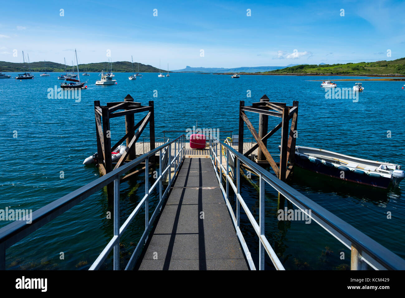 Schwimmende Anlegestelle auf dem Loch nan Ceall See loch im Hafen von Arisaig, Schottland, Großbritannien, mit der Sgurr von Eigg auf der Isle of Eigg in der Ferne. Stockfoto
