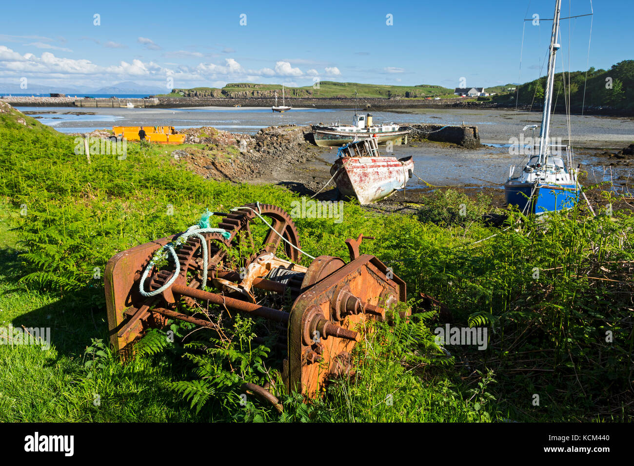 Boote und eine alte Windenmechanismus am alten Hafen, Galmisdale Bay auf der Isle of Eigg, Schottland, UK Stockfoto