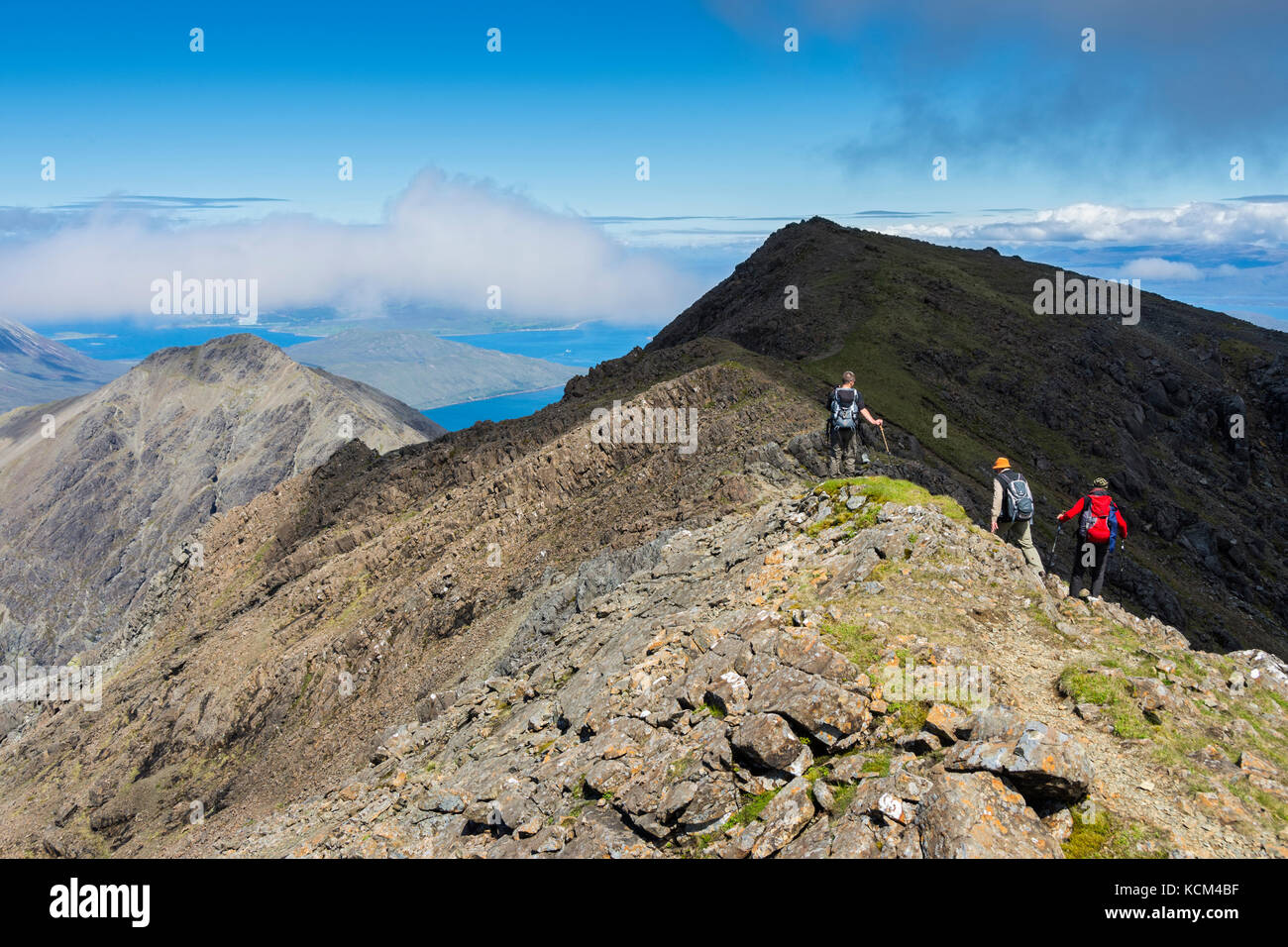 Wanderer auf dem Gipfelgrat des Bla Bheinn, der vom unteren östlichen Gipfel zum Hauptgipfel führt. Isle of Skye, Schottland, Großbritannien. Stockfoto