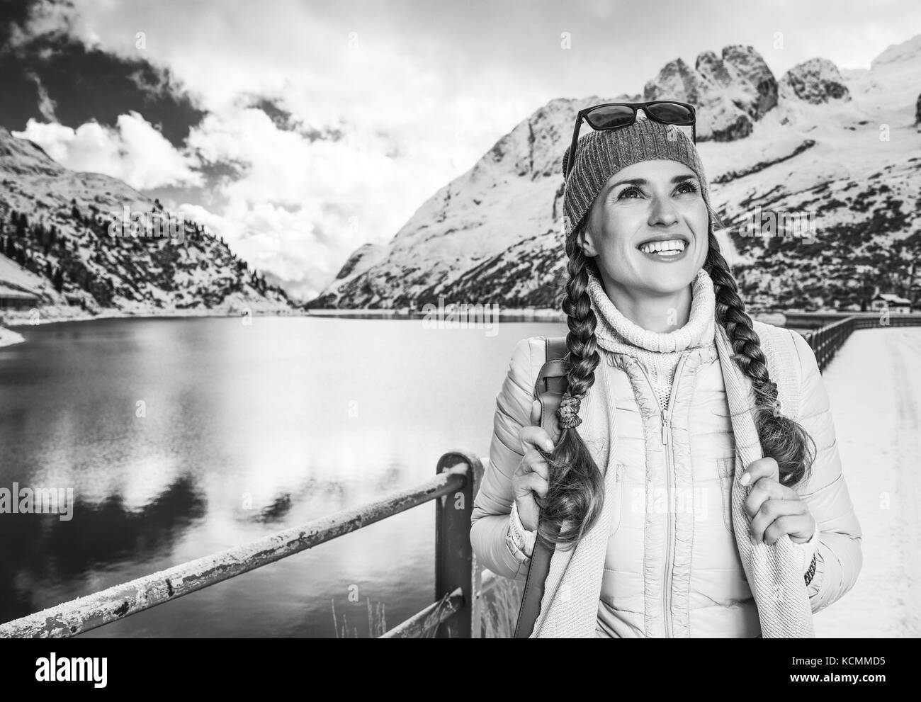Winter auf höherer Ebene Spaß. lächelnden jungen Reisenden Frau gegen Berglandschaft mit See in Südtirol, Italien, in die Ferne Stockfoto