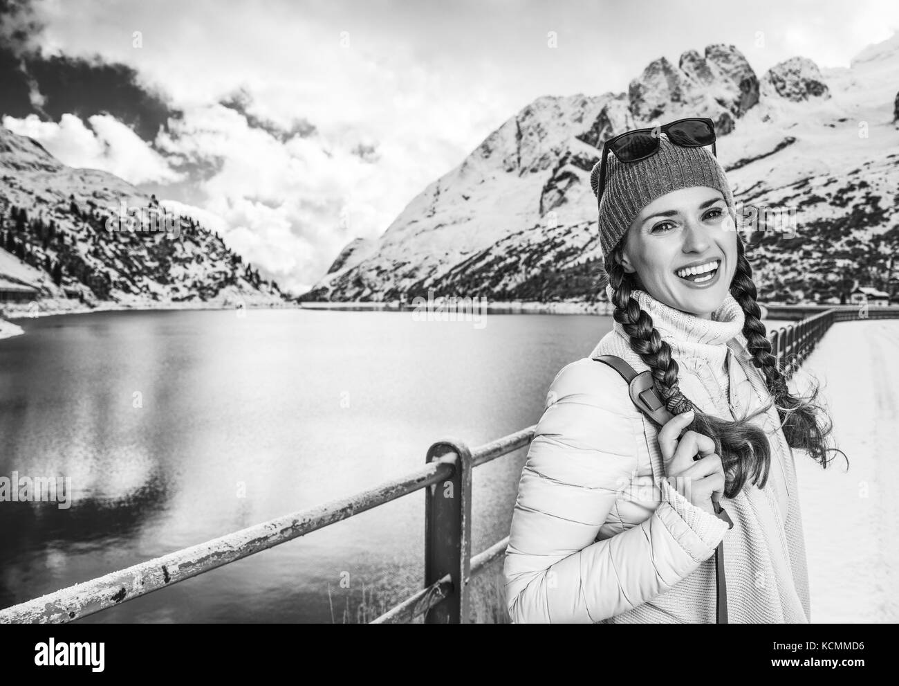 Winter auf höherer Ebene Spaß. Portrait von lächelnden modernen Reisenden Frau in der Berglandschaft mit See in Alto Adige, Italien Stockfoto
