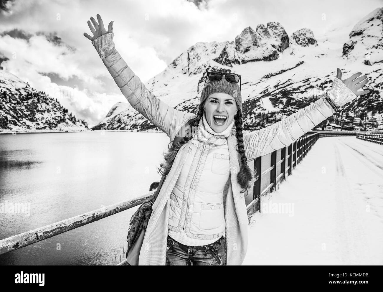 Winter auf höherer Ebene Spaß. Portrait von Happy stilvolle reisenden Frau in der Berglandschaft mit See in Alto Adige, Italien Freude Stockfoto