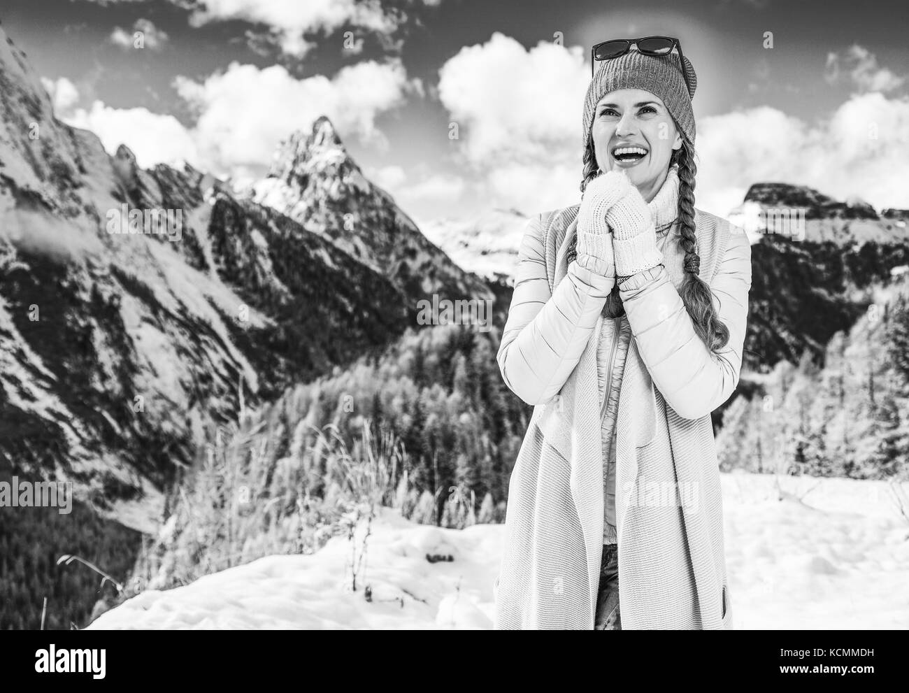 Winter auf höherer Ebene Spaß. Portrait von lächelnden modernen Reisenden Frau in der Bergwelt in Südtirol, Italien Erwärmung der Hände mit Br Stockfoto