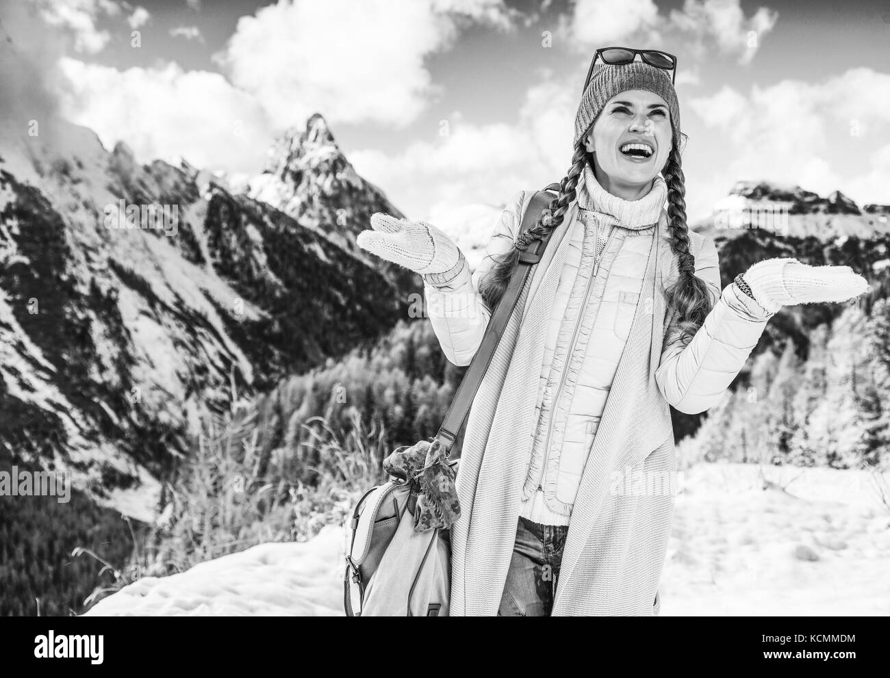 Winter auf höherer Ebene Spaß. Lächeln auf den modernen Reisenden Frau in der Berglandschaft in Alto Adige, Italien Schneeflocken fangen Stockfoto