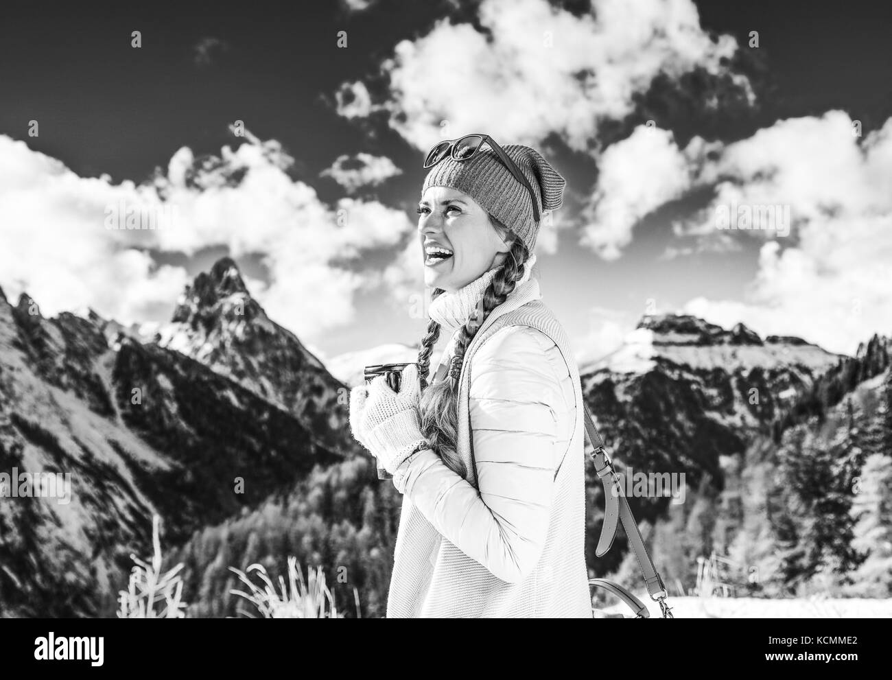 Winter auf höherer Ebene Spaß. lächelnden Jungen touristische Frau gegen Bergwelt in Südtirol, Italien mit thermos Travel Mug Stockfoto