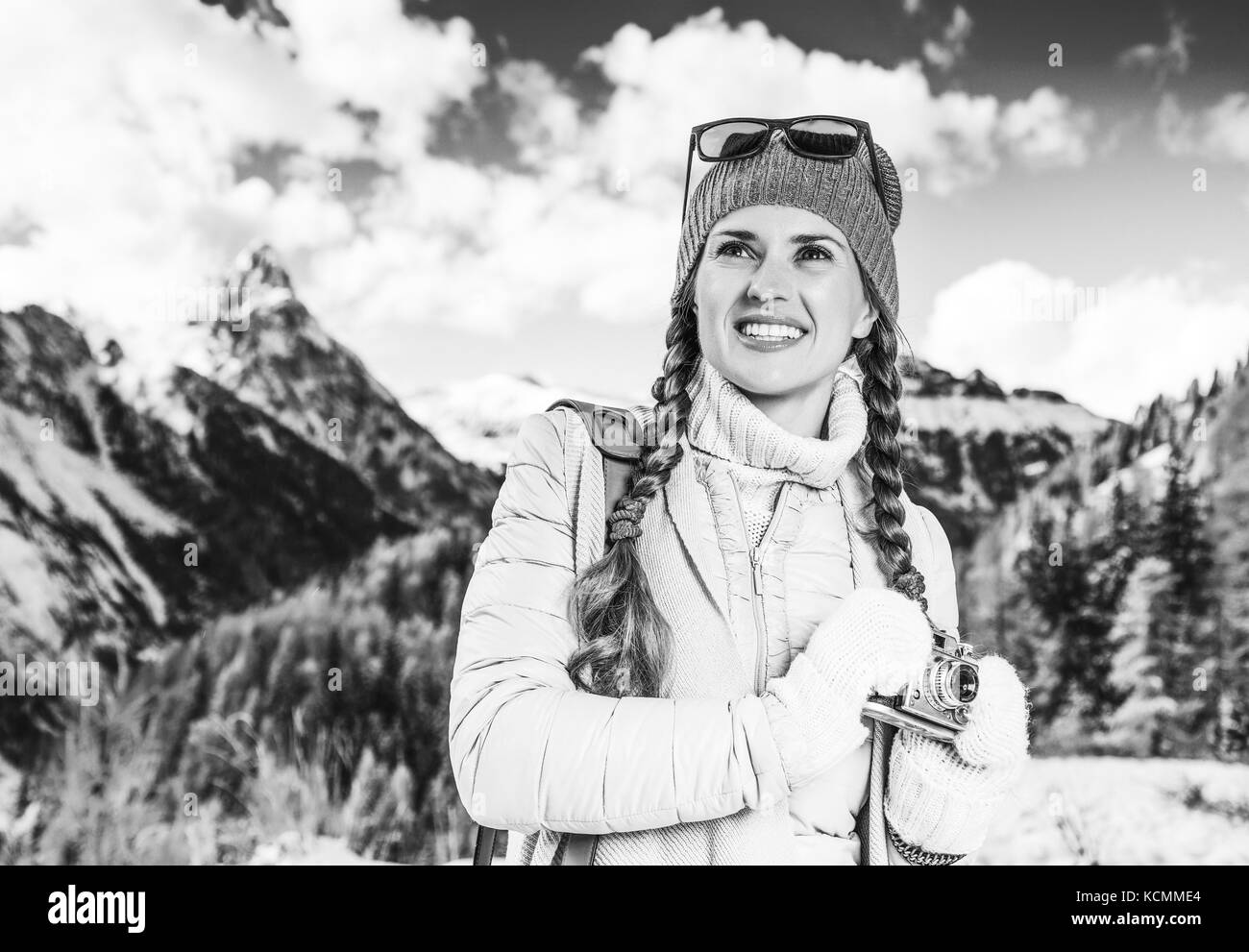 Winter auf höherer Ebene Spaß. Glücklich moderne reisende Frau in Südtirol, Italien mit Vintage Foto Kamera in die Ferne suchen Stockfoto