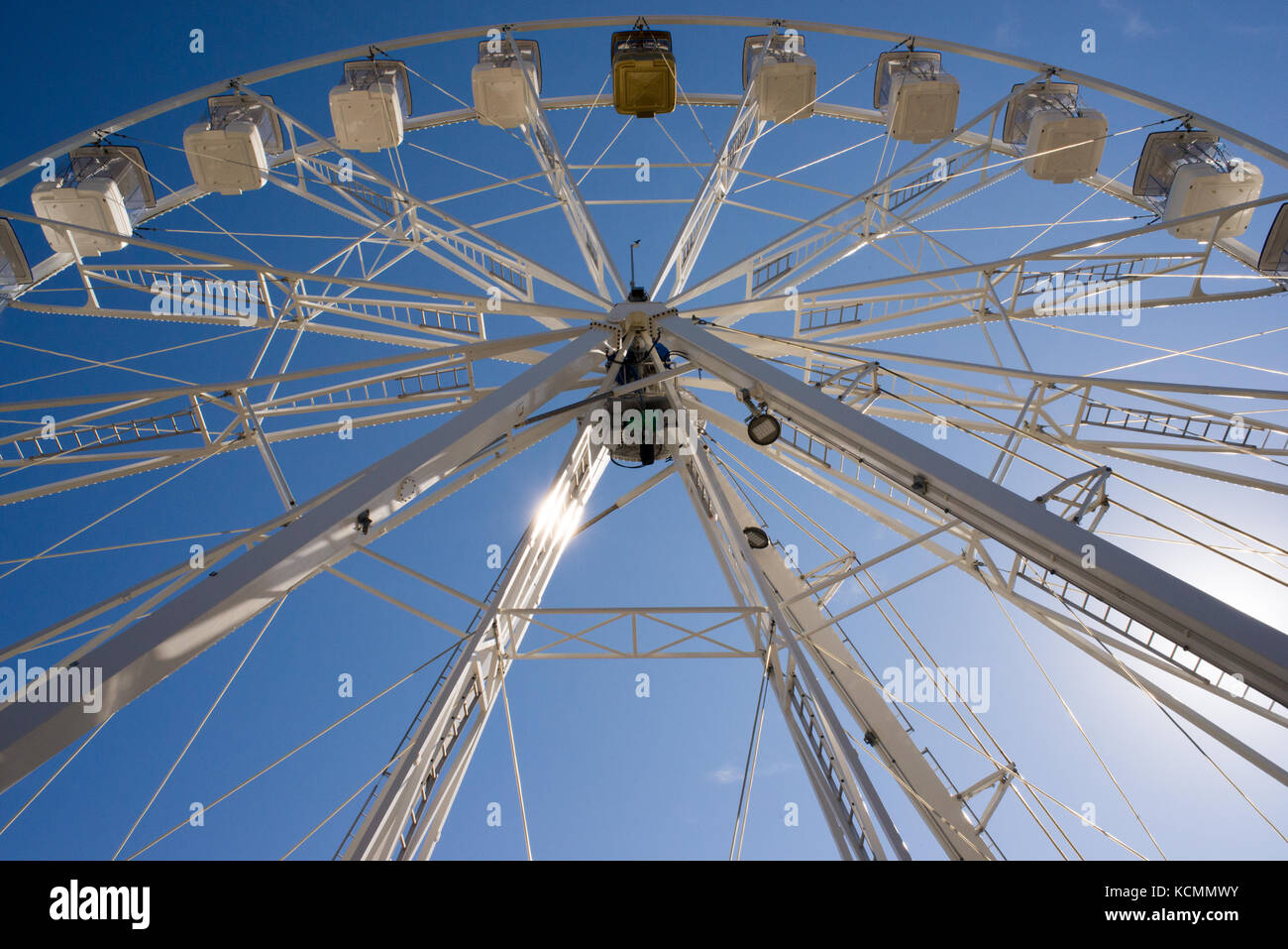 Eine weiße Riesenrad mit Kabinen von unten gegen den blauen Himmel gesehen Stockfoto