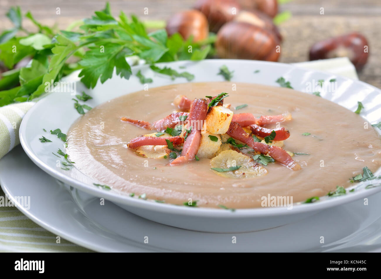 Köstliche Kastaniensuppe mit Sellerie, Croutons und gebratenem Speck Stockfoto