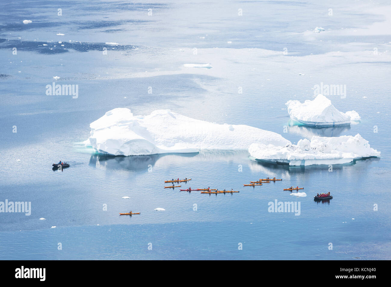 Kajakfahrer und zodiaks konvergieren in der Nähe von einem Eisberg, wo ein Buckelwal schwimmen gesehen wurde, danco Island, Antarktische Halbinsel Stockfoto