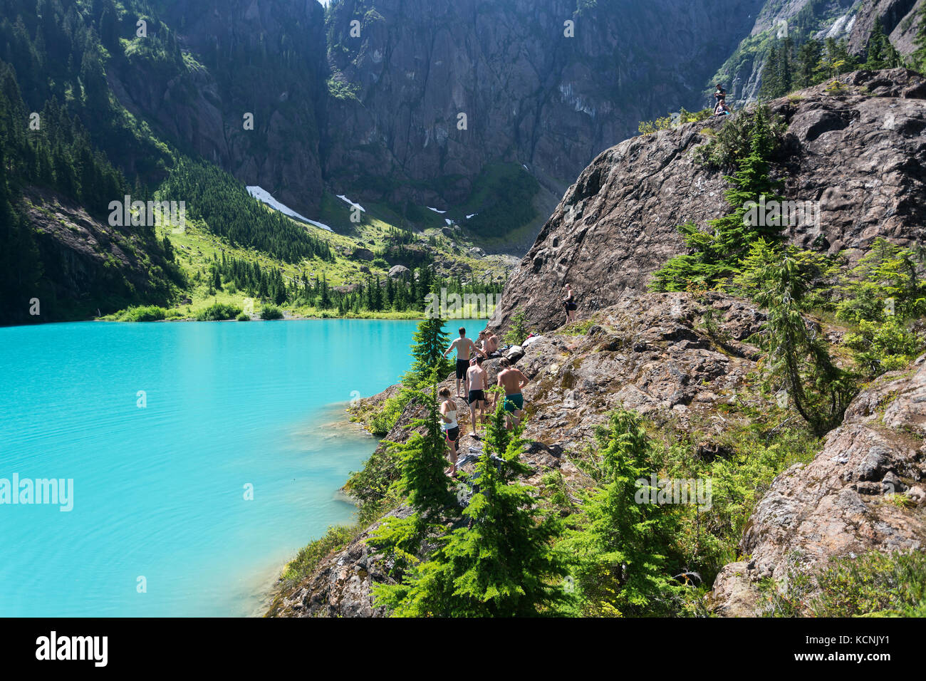 Freunde bereiten sich darauf vor, in das tourquise Wasser des Century Sam Sees im Strathcona Park einzutauchen. Vancouver Island, British Columbia, Kanada. Stockfoto