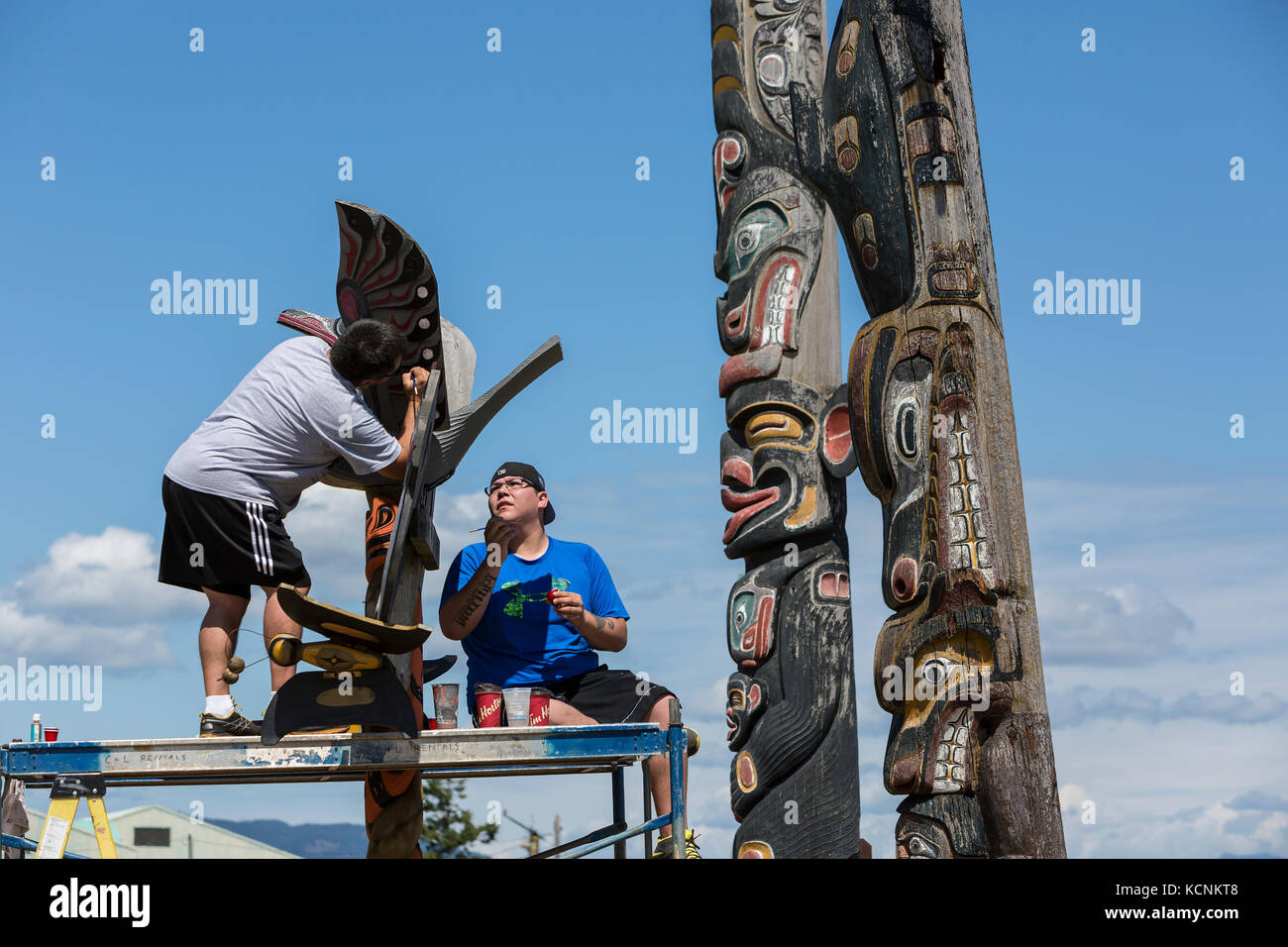 Zwei erste Nationen Familienmitglieder eines Angehörigen memorial Pole sanieren, Campbell River Stockfoto