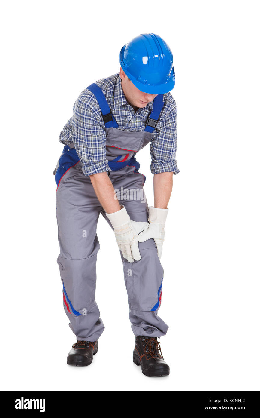 Männliche Arbeitnehmer leiden unter Knieschmerzen auf weißem Hintergrund Stockfoto