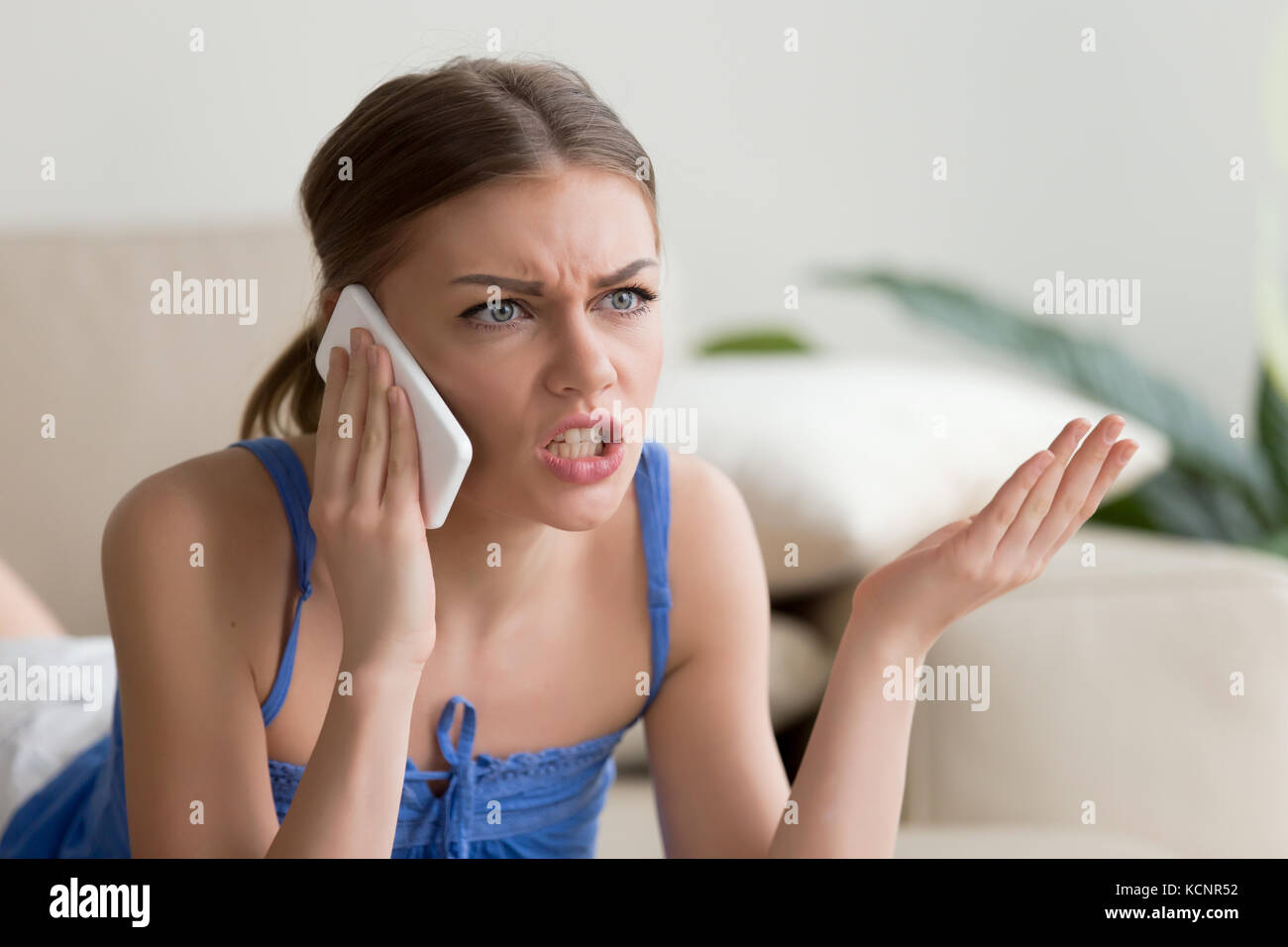 Zornige junge Frau argumentieren am Telefon sprechen zu Hause, unzufrieden Mädchen, Kundenservice, Problem des Konflikts während Telefon conversati Stockfoto