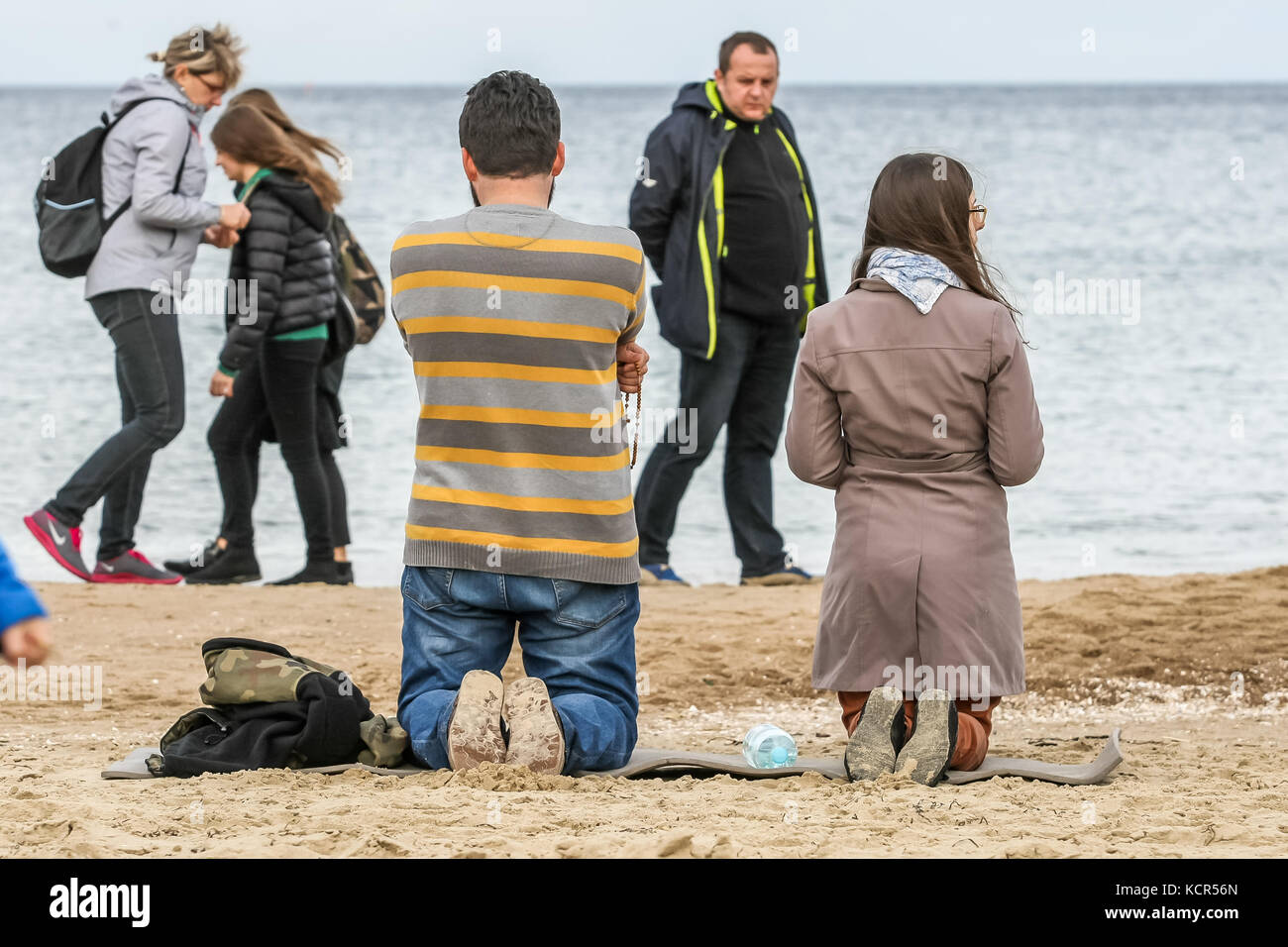 Danzig, Polen. Oktober 2017. Katholiken Gläubige, die am Ufer der Ostsee knieten und einen Rosenkranz beten, werden am 7. Oktober 2017 in Danzig, Polen, gesehen. Polnische Katholiken wurden eingeladen, an einem Rosenkranzgebet entlang der 3.500 Kilometer langen Grenze countryÕs teilzunehmen, um für „ihre Heimat und die ganze Welt“ zu beten. Der 7. Oktober wird in der römisch-katholischen Kirche als fest der Muttergottes vom Rosenkranz gefeiert. Insgesamt wurden 319 Kirchen in der Nähe der polnischen Grenzen als Sammelpunkte für die Veranstaltung ausgewählt. Quelle: Michal Fludra/Alamy Live News Stockfoto