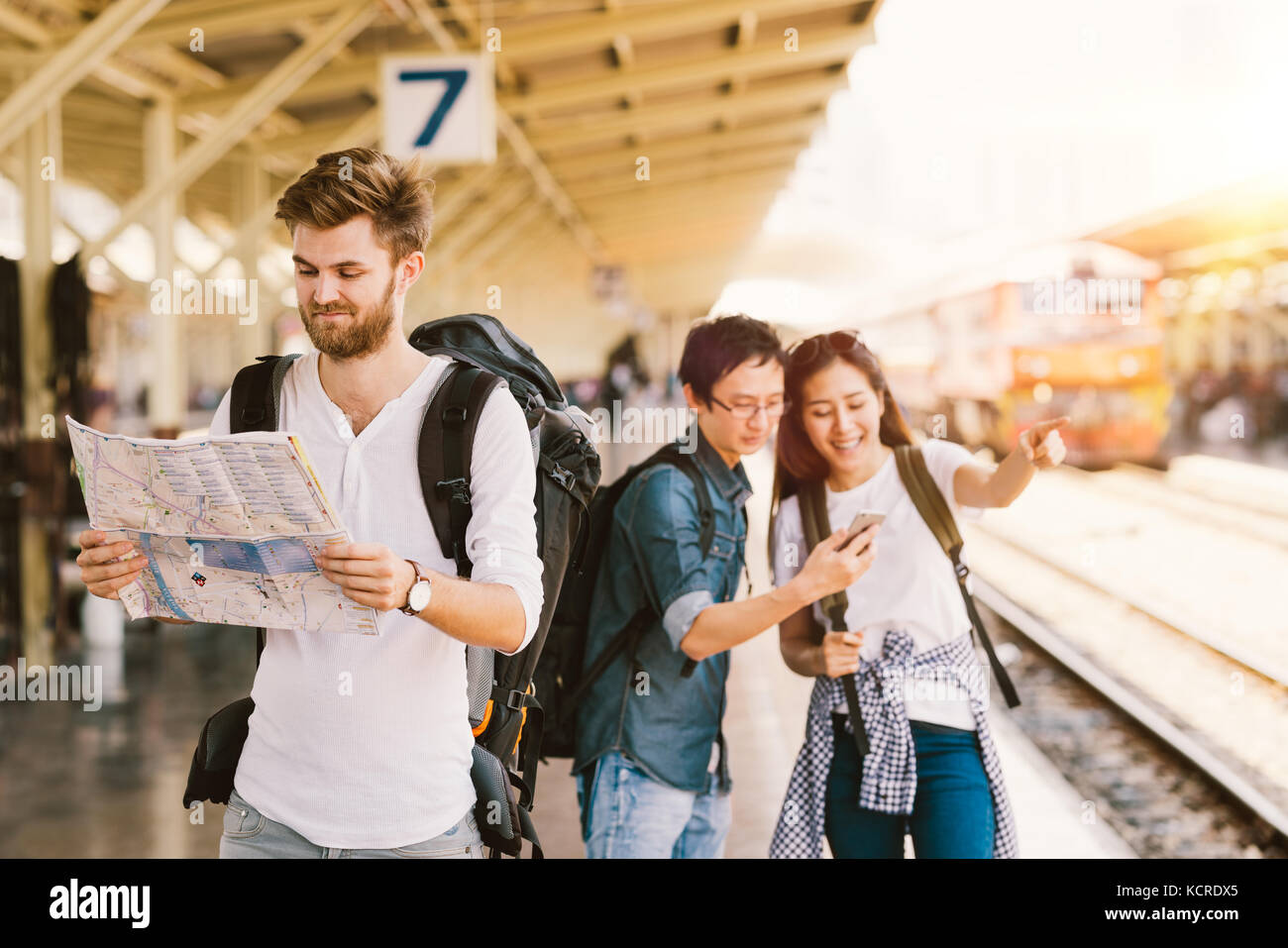 Multiethnische Gruppe von Rucksack Reisenden mit Karte und Smartphone Navigation am Bahnhof, asiatischen Tourismus Aktivität oder mobile phone technology Konzept Stockfoto