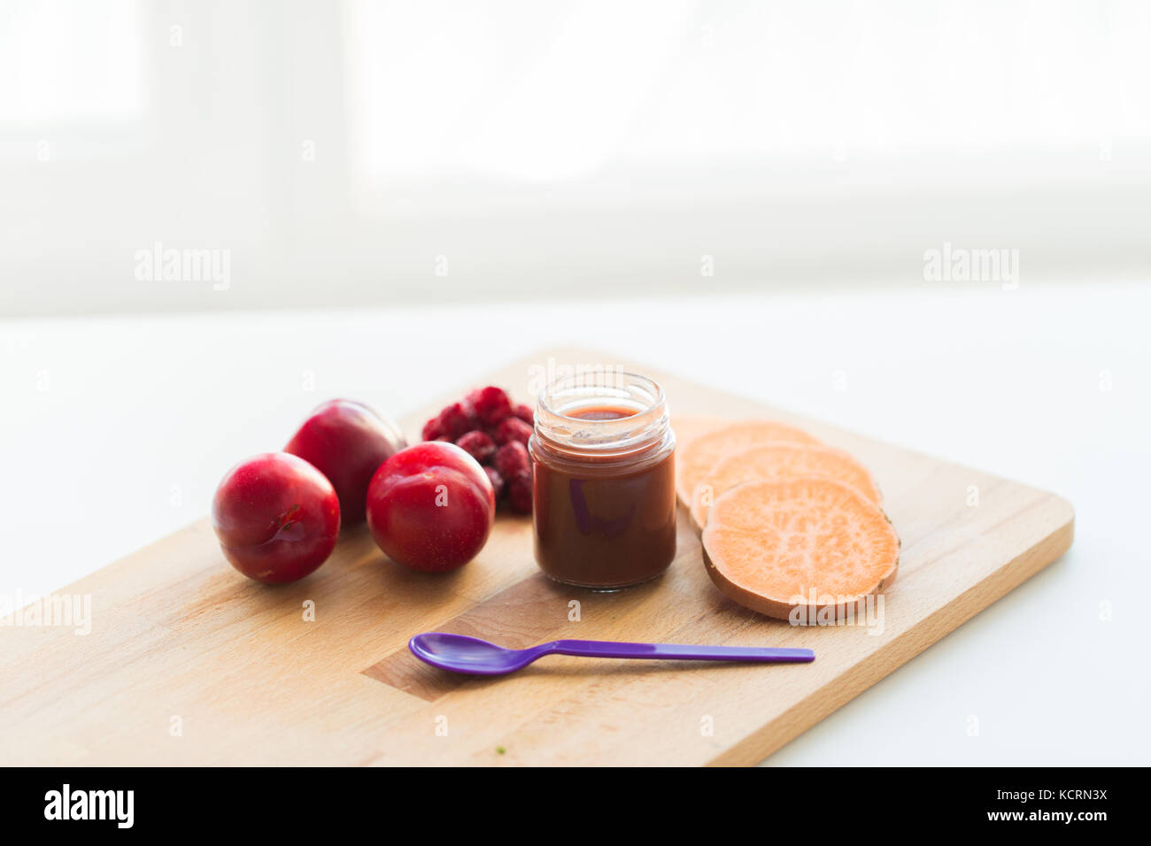 Fruchtpüree oder Babynahrung im Glas und Fütterlöffel Stockfoto