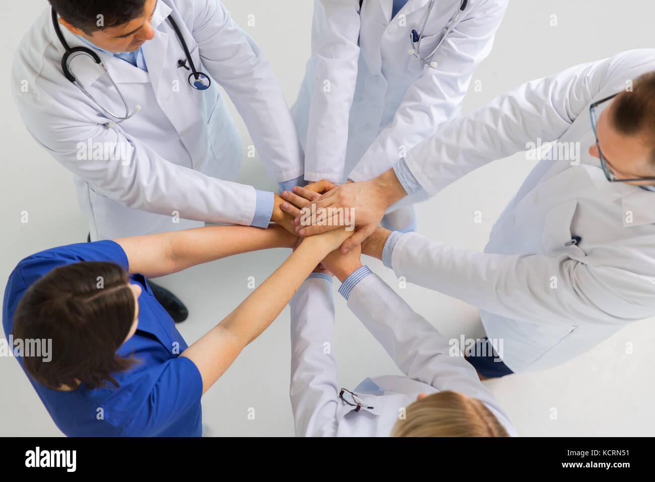 Gruppe von Ärzten mit Hände zusammen am Krankenhaus Stockfoto