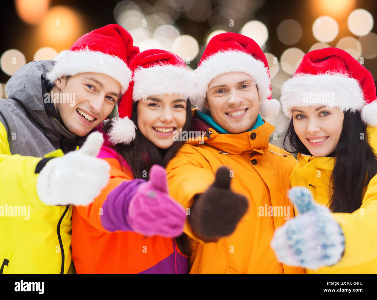 Glückliche Freunde in Santa Hüte und Skianzüge im freien Stockfoto