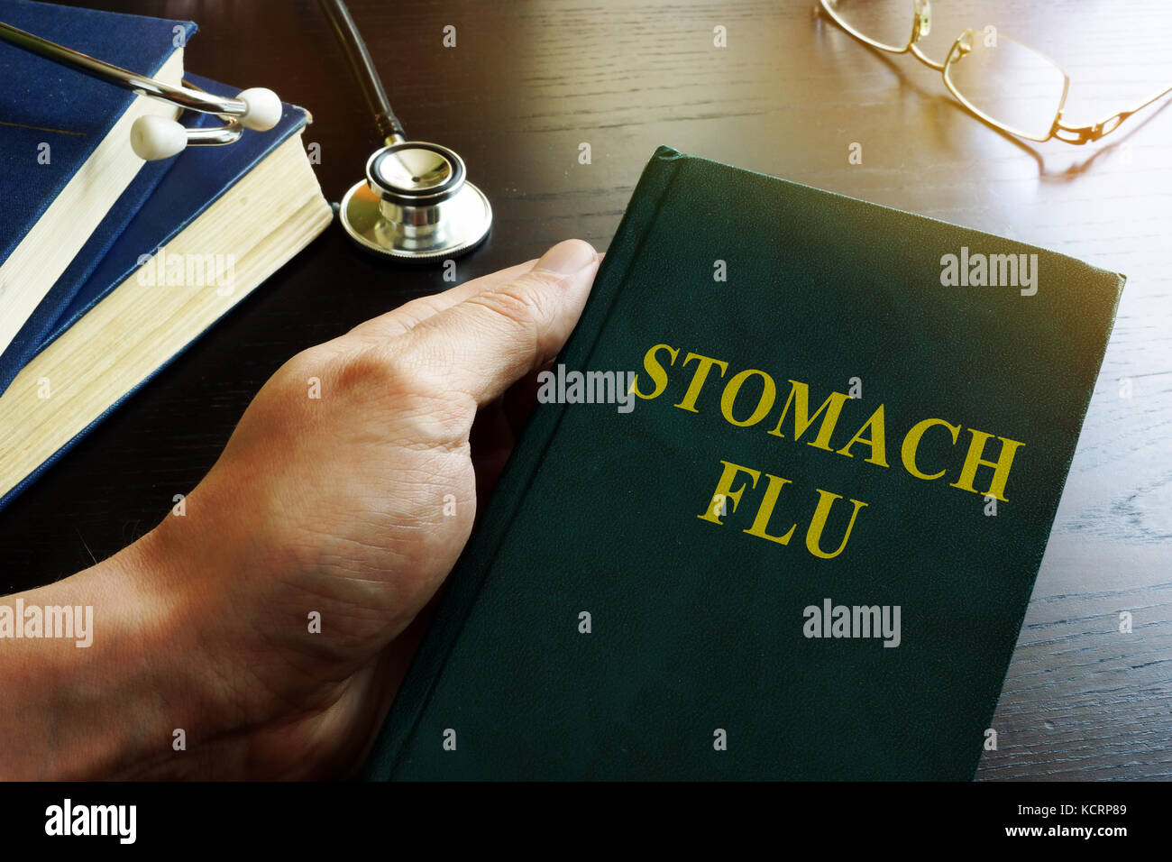 Arzt holding Buch über Magen-Darm-Grippe. Stockfoto