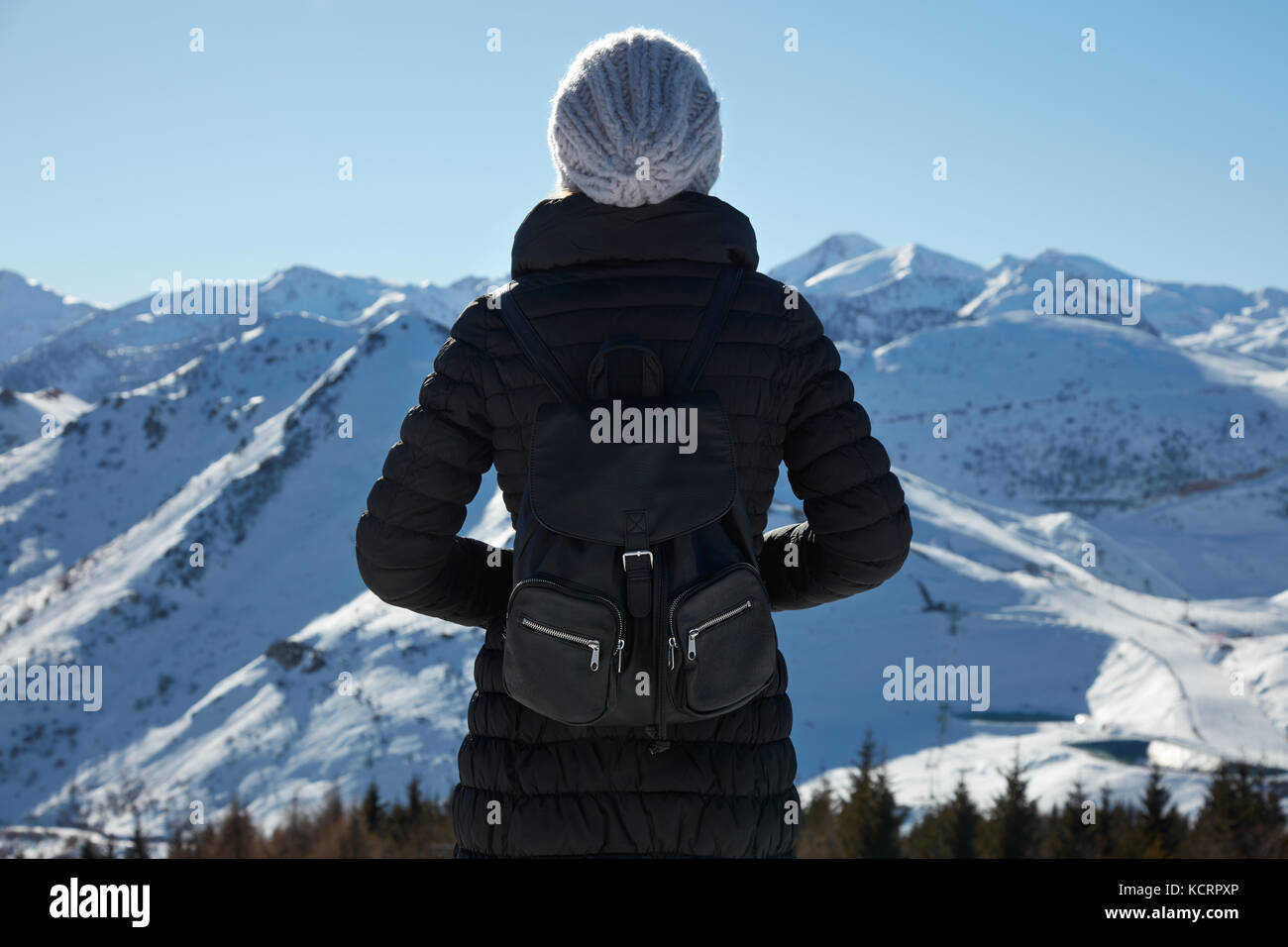 Frau mit Blick auf die Berge mit Schnee an einem sonnigen Wintertag Stockfoto