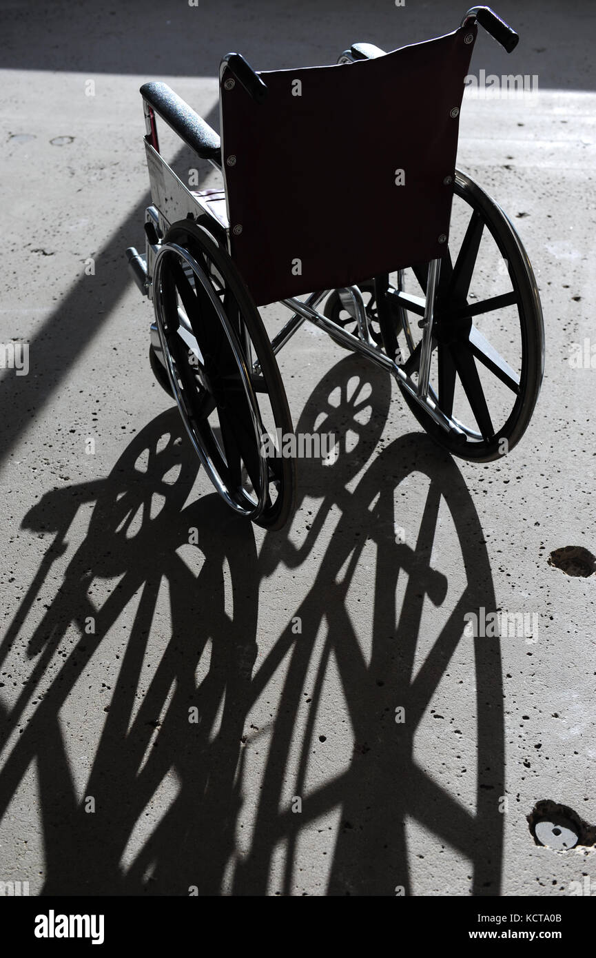 Einen leeren Rollstuhl in einem Gebäude mit einem Betonboden Stockfoto