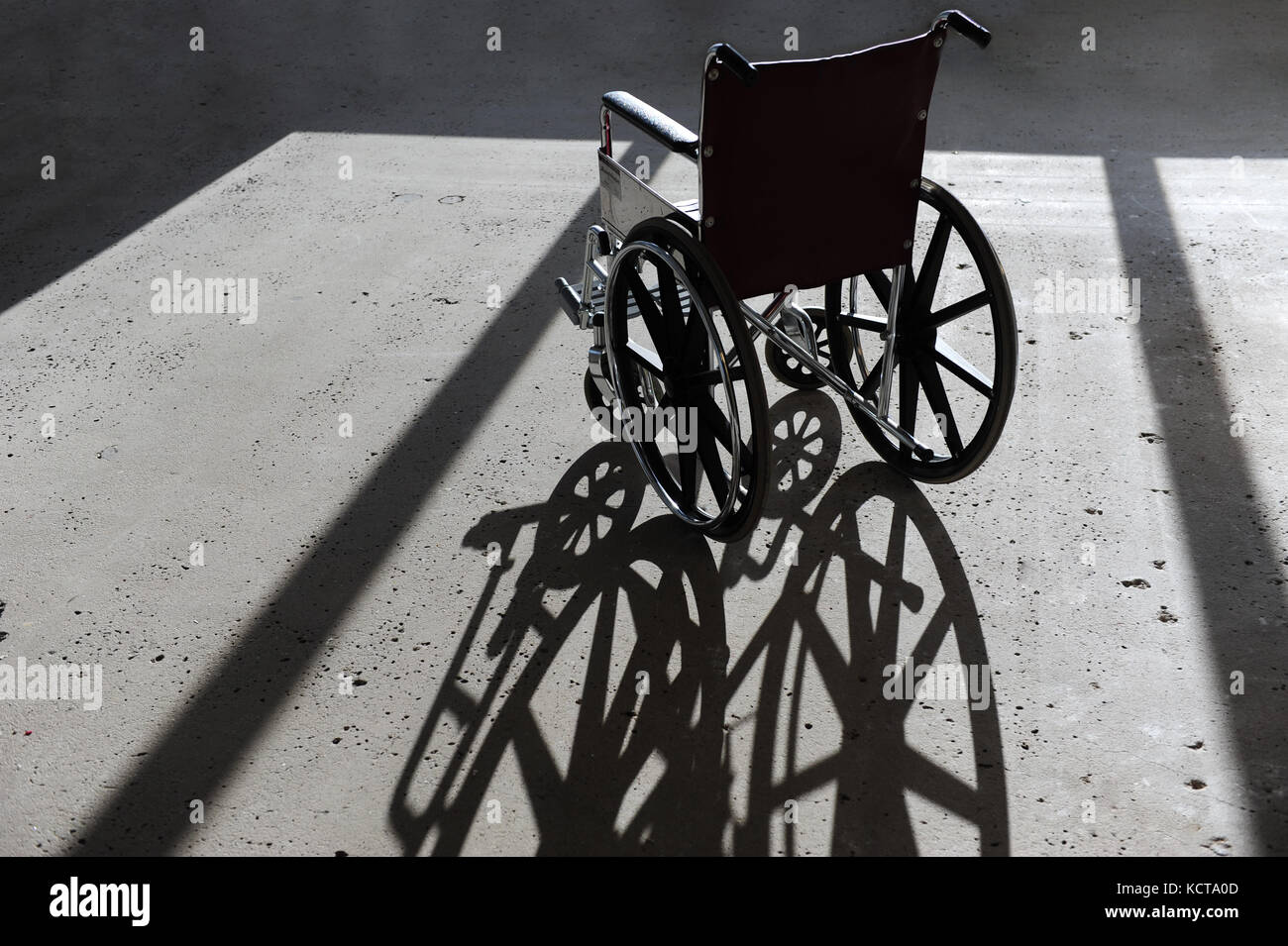 Einen leeren Rollstuhl in einem Gebäude mit einem Betonboden Stockfoto