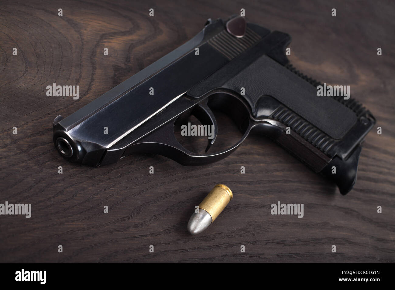 Pistole mit Munition auf dem hölzernen Tisch Stockfoto