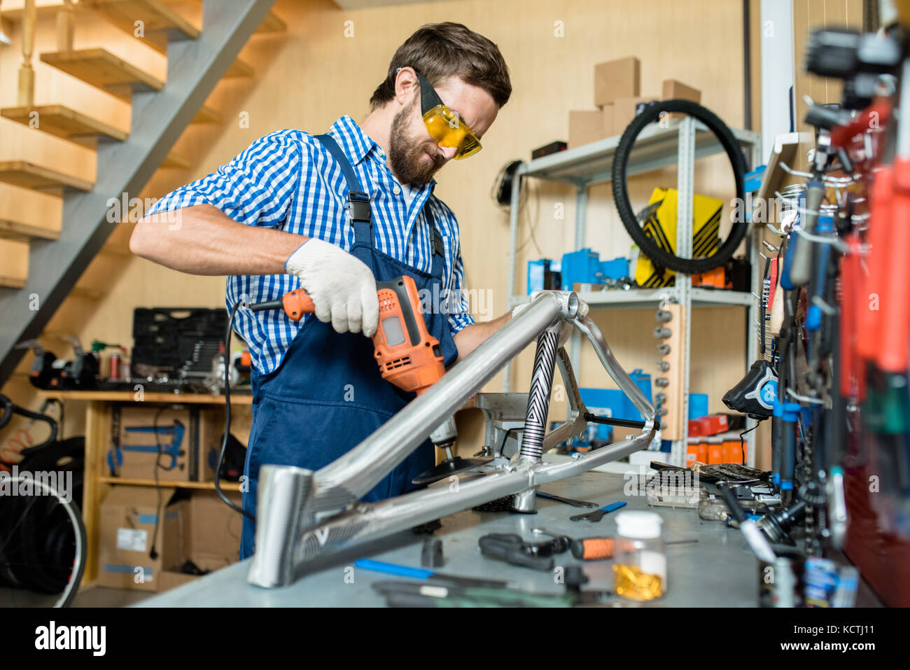 Handwerker arbeiten mit elektrischen Bohrmaschine mit Arbeitsplatz in seiner eigenen Werkstatt Stockfoto