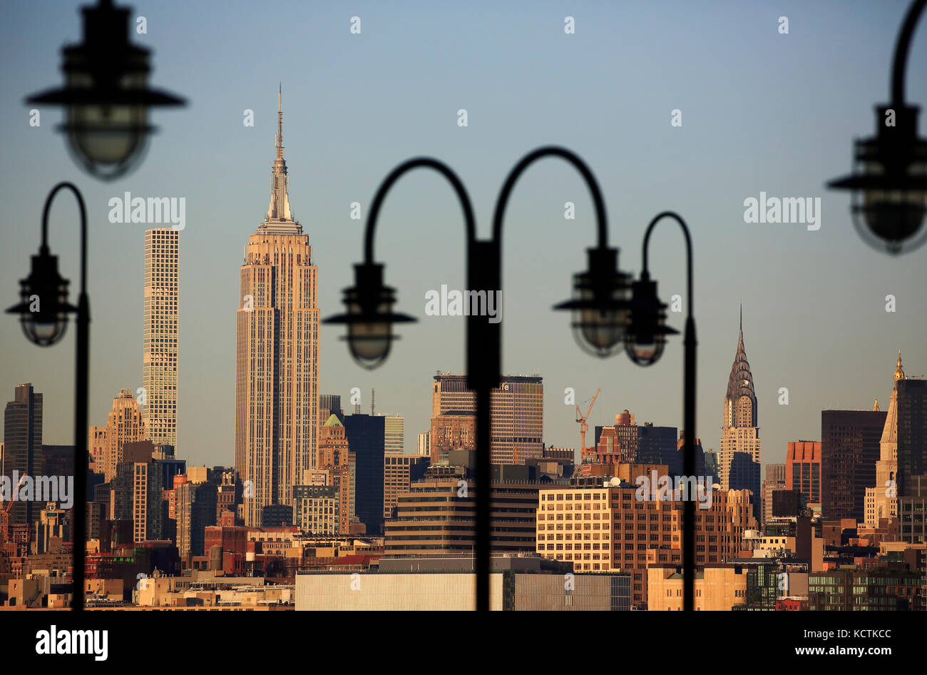 Empire State Building und Skyline von Midtown Manhattan, eingerahmt durch die Laternenpfosten der alten Fähranlegestelle im Liberty State Park. Jersey City.New Jersey.USA Stockfoto